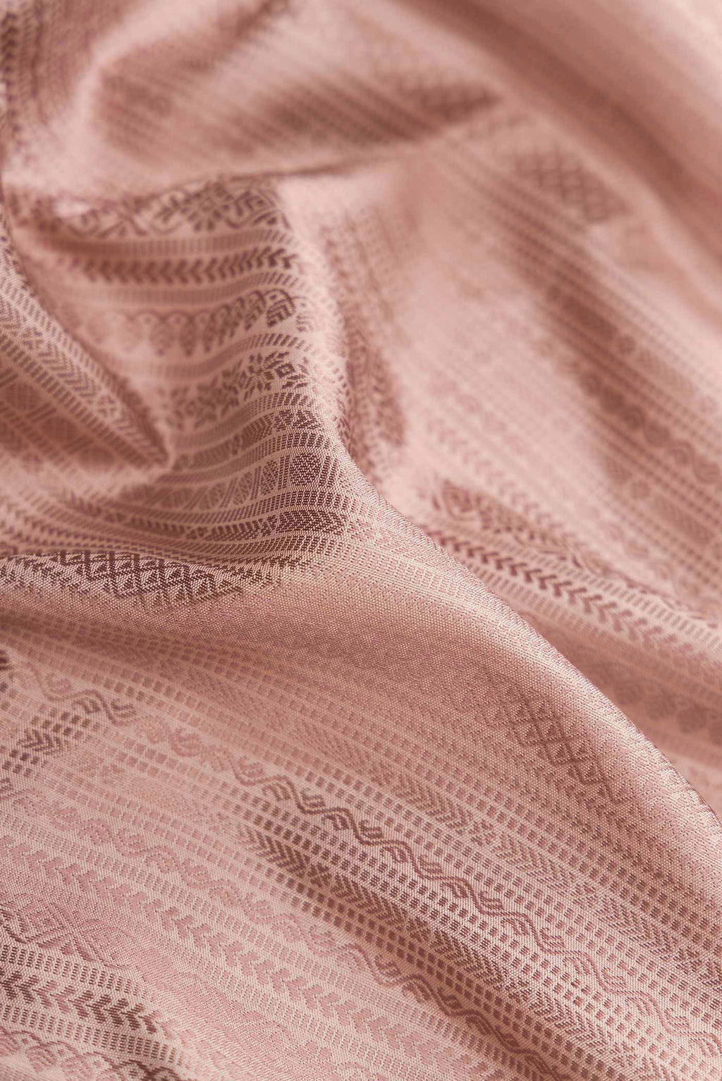 Close up of Pure Silk Pure Zari Rose Gold Dual Tone Kanchipuram Saree with Jacquard design on the body and Zari Border.  displaying folds