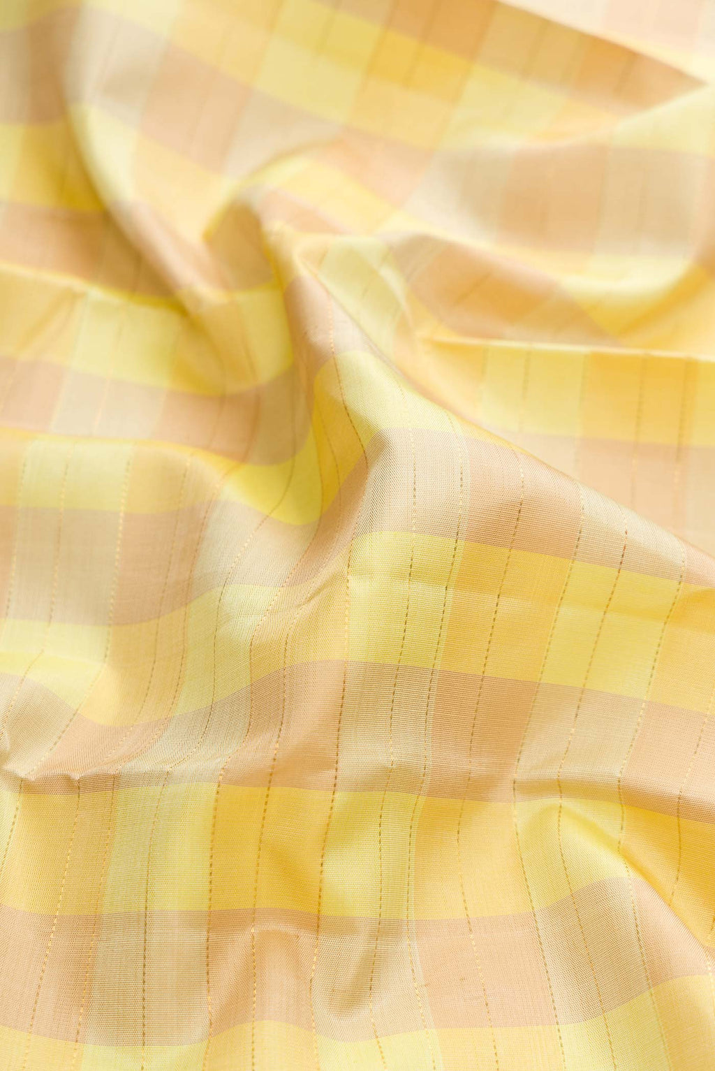 Close up of Pure Silk Pure Zari Lemon Yellow and Mustard Color Kanchipuram Saree with Checked design on the body and Zari Border displaying folds