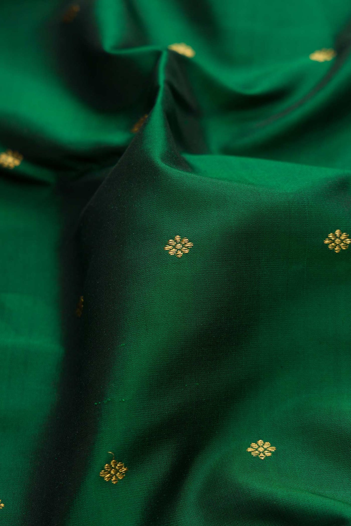 Close up of Pure Silk Pure Zari Bottle Green Dual Tone Kanchipuram Saree with Zari Butta on the body and Zari Border displaying folds