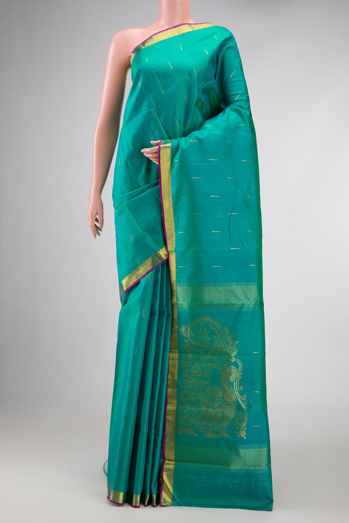 Green Dual Tone Kanchipuram Silk Saree with Zari Butta on the body and Zari Border.  displayed on a mannequin