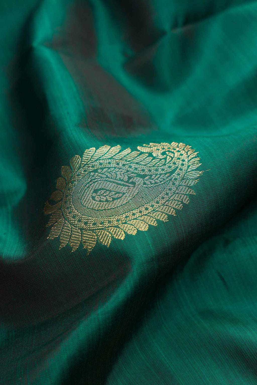 Close up of Bottle Green Dual Tone Kanchipuram Silk Saree with Zari Butta on the body and Zari Border.  displaying folds