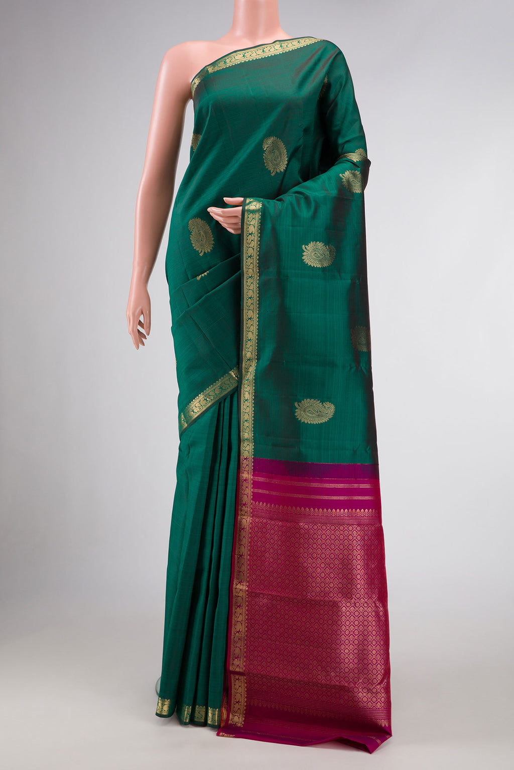 Bottle Green Dual Tone Kanchipuram Silk Saree with Zari Butta on the body and Zari Border.  displayed on a mannequin