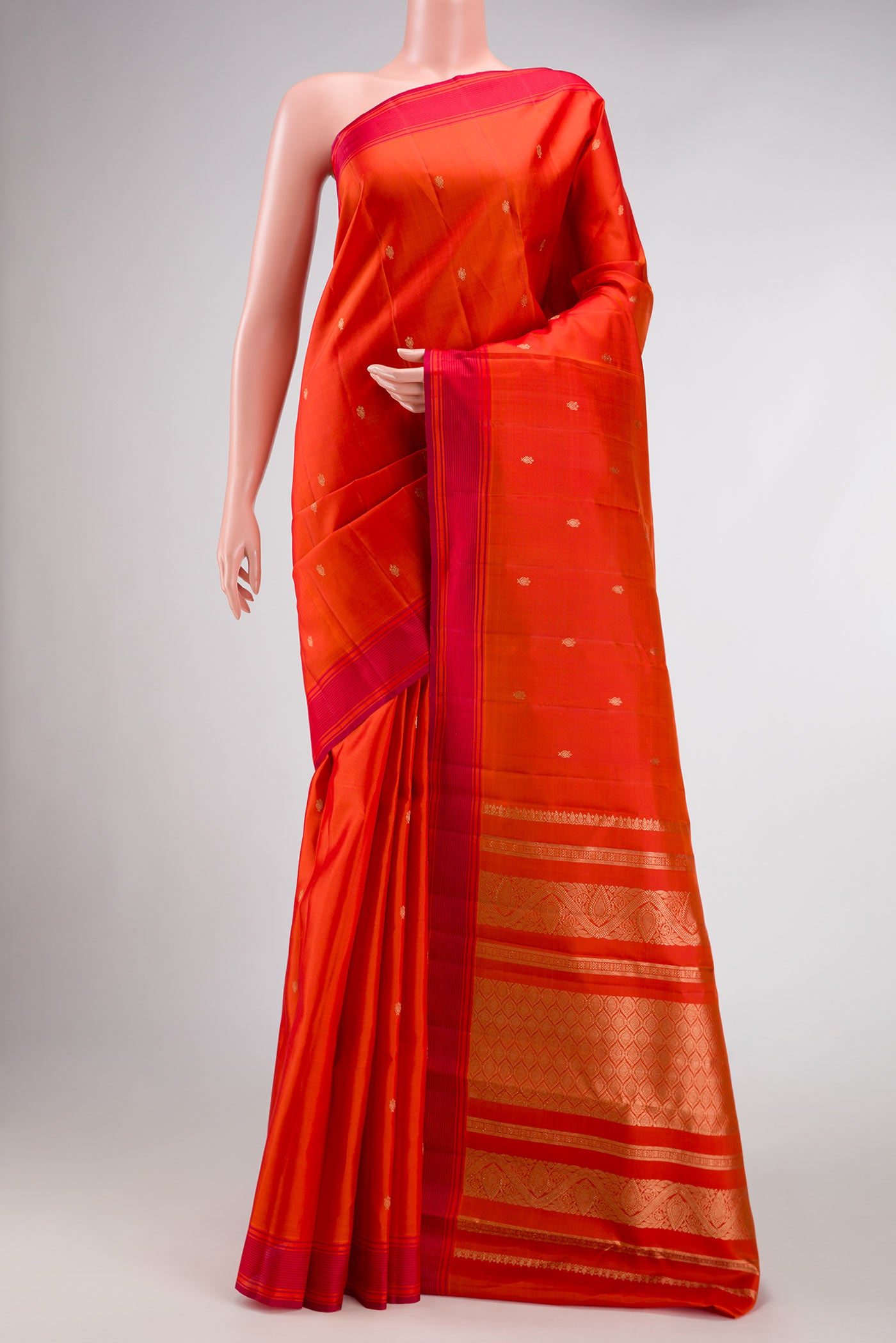 Orange Dual Tone Kanchipuram Silk Saree with Zari Butta on the body and Thread Border.  displayed on a mannequin