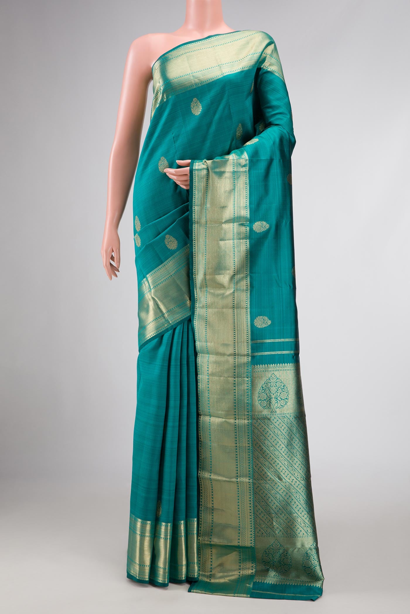 Green Dual Tone Kanchipuram Silk Saree with Zari Butta on the body and Zari Border.  displayed on a mannequin