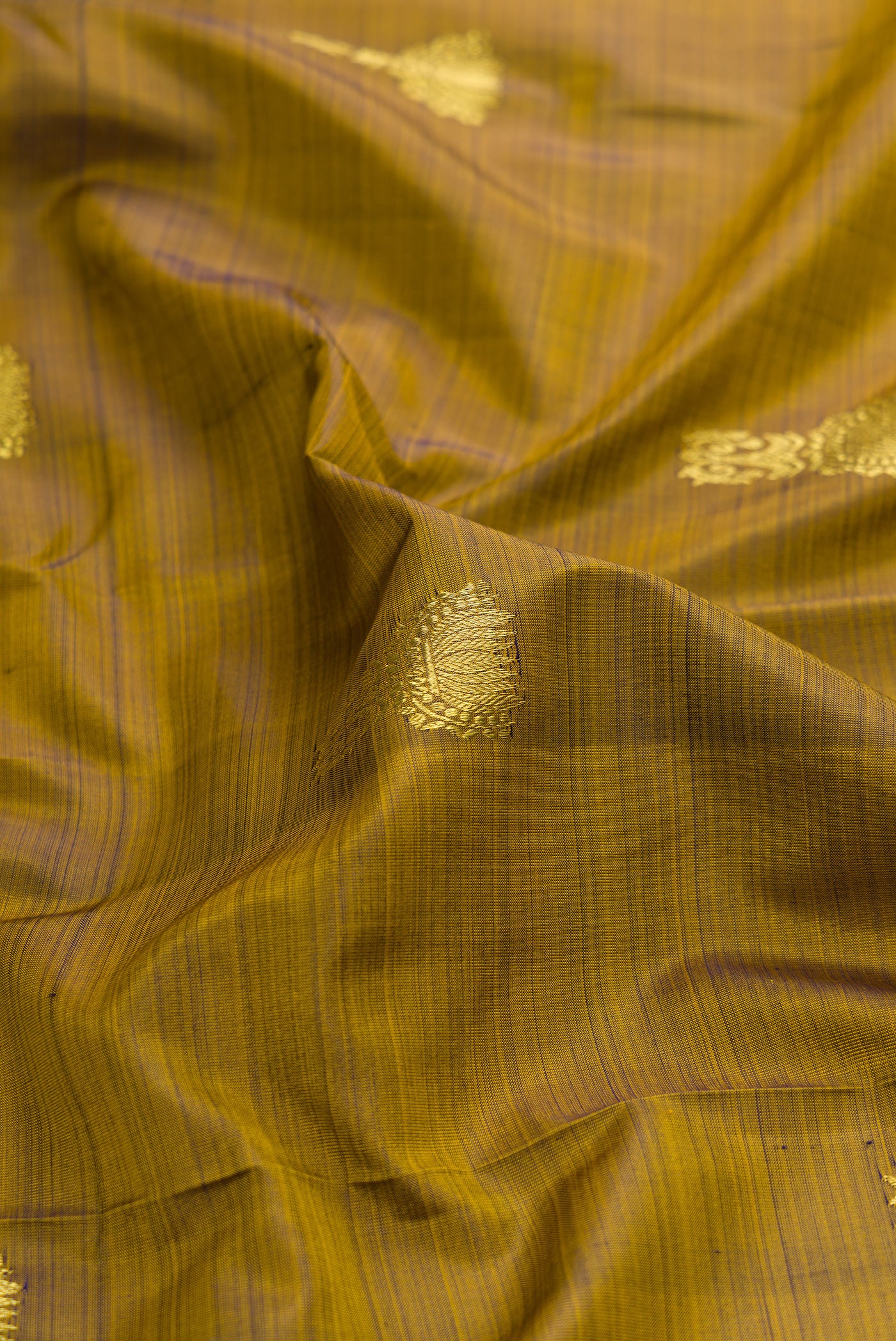 Close up of Mehandi Green Dual Tone Kanchipuram Silk Saree with Zari Butta on the body and Zari Border.  displaying folds