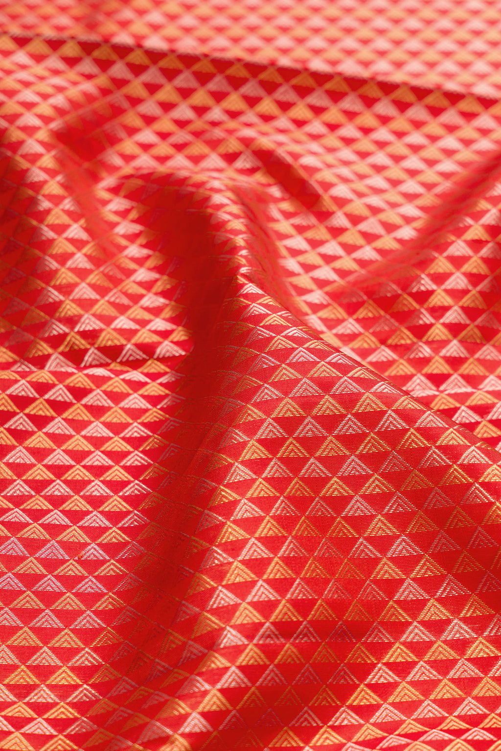Close up of Orange Kanjivaram Silk Saree with Zari Brocade on the body and Zari Border.  displaying folds