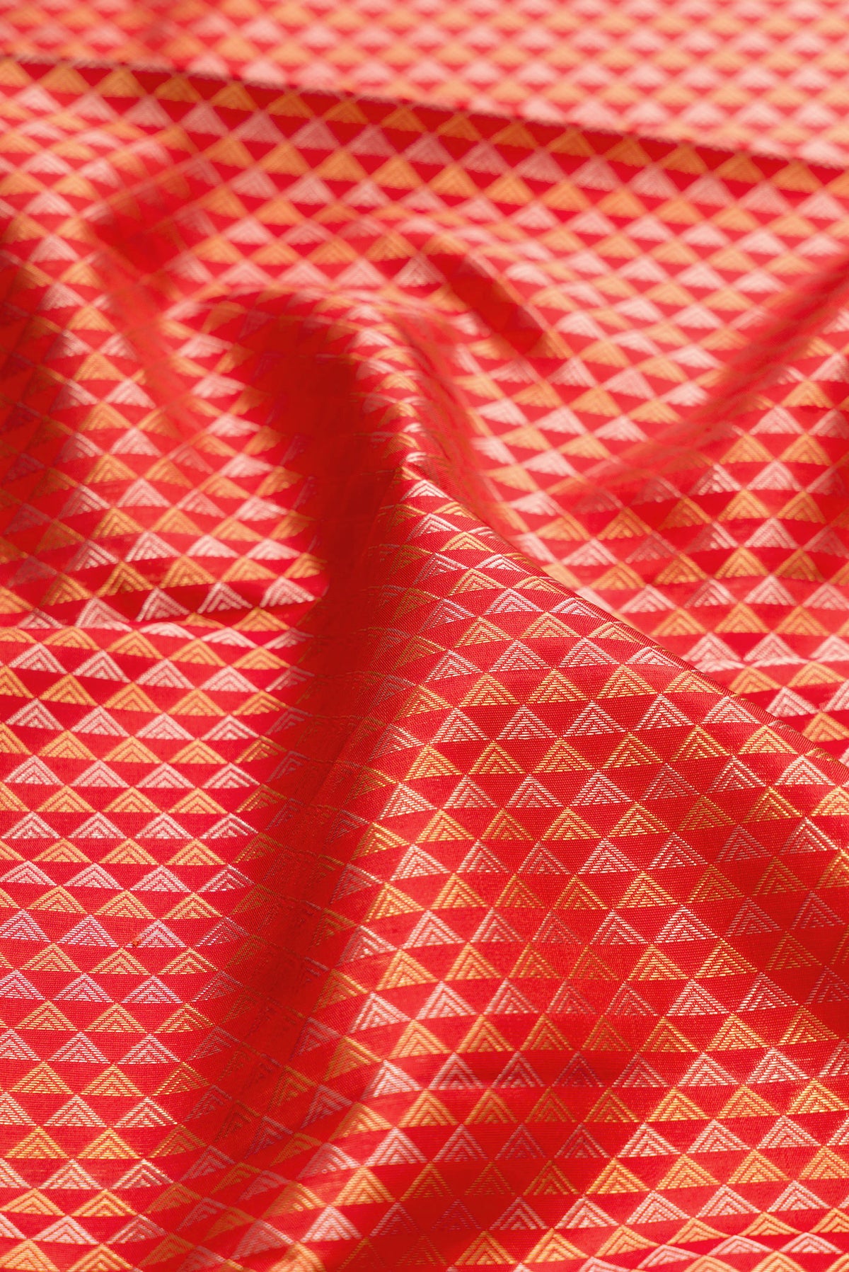 Close up of Orange Kanjivaram Silk Saree with Zari Brocade on the body and Zari Border.  displaying folds
