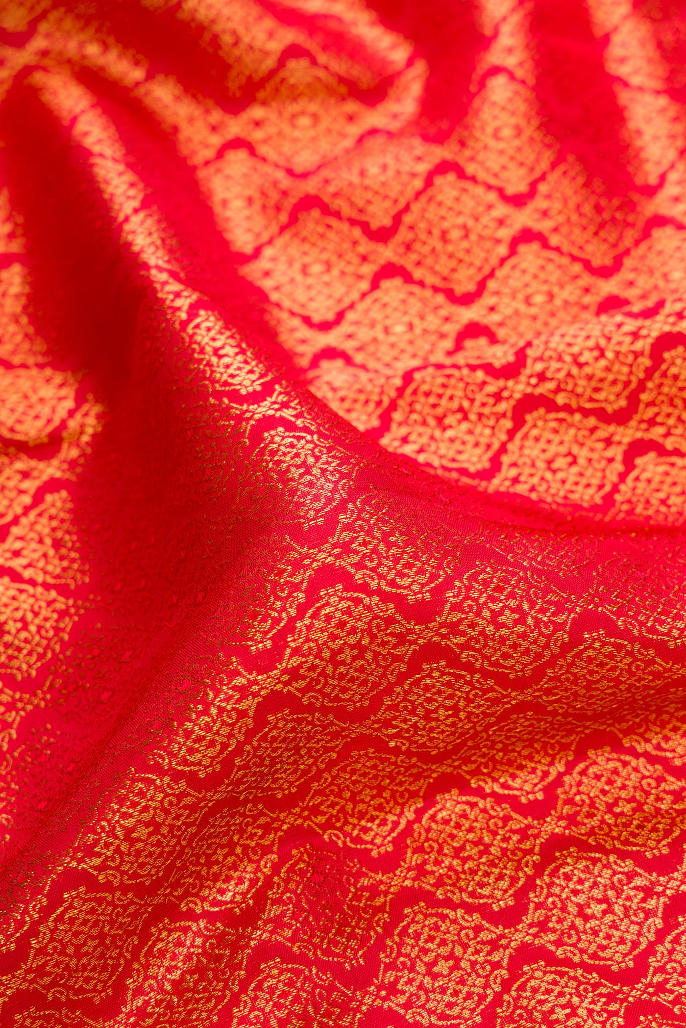 Close up of Red Dual Tone Kanjivaram Silk Saree with Zari Brocade on the body and Fancy Border.  displaying folds