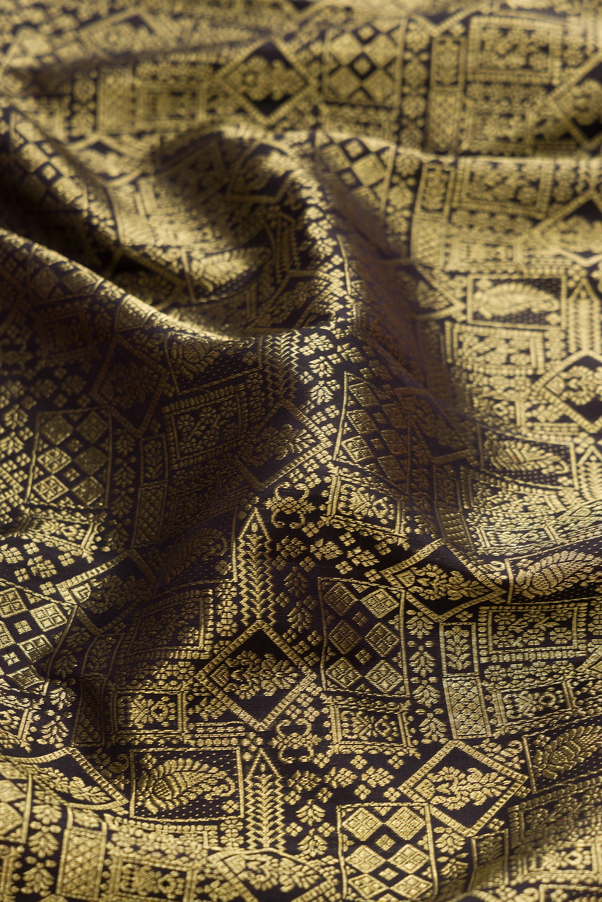 Close up of Black Dual Tone Kanjivaram Silk Saree with Zari Brocade on the body and Zari Border.  displaying folds