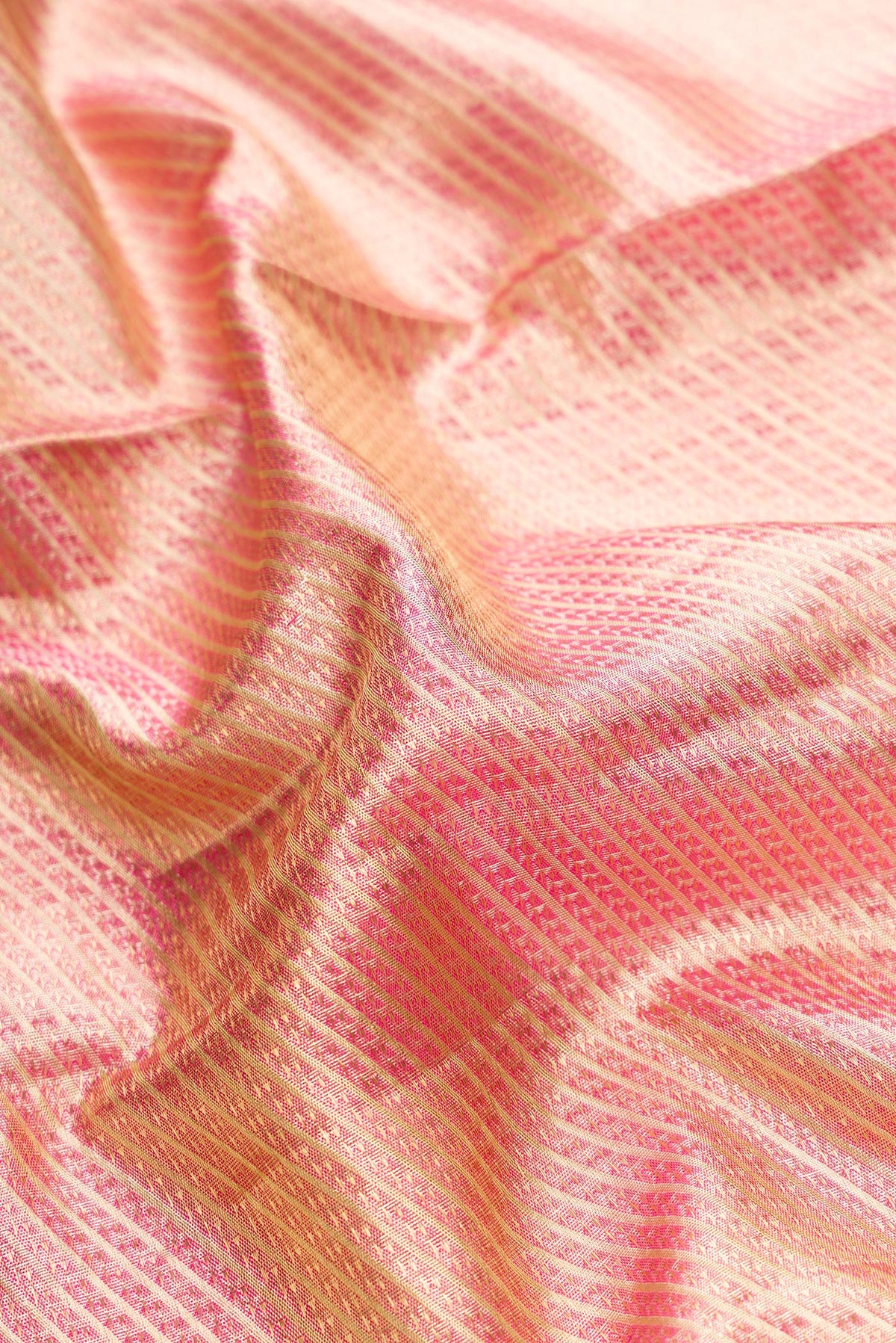 Close up of Golden Peach Dual Tone Kanjivaram Tissue Silk Saree with Zari Brocade on the body and Zari Border.  displaying folds