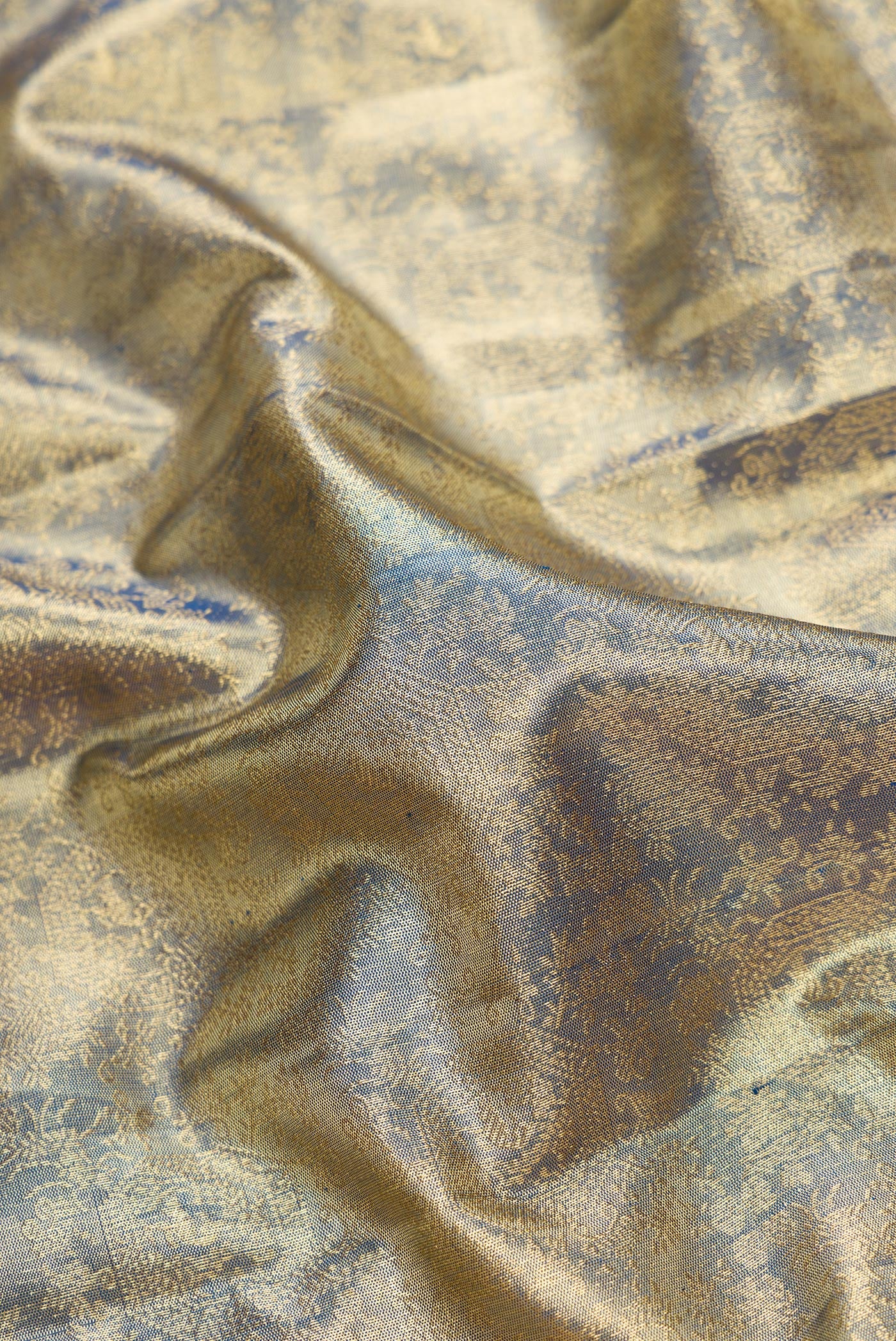 Close up of Green Dual Tone Kanjivaram Tissue Silk Saree with Zari Brocade on the body and Zari Border.  displaying folds