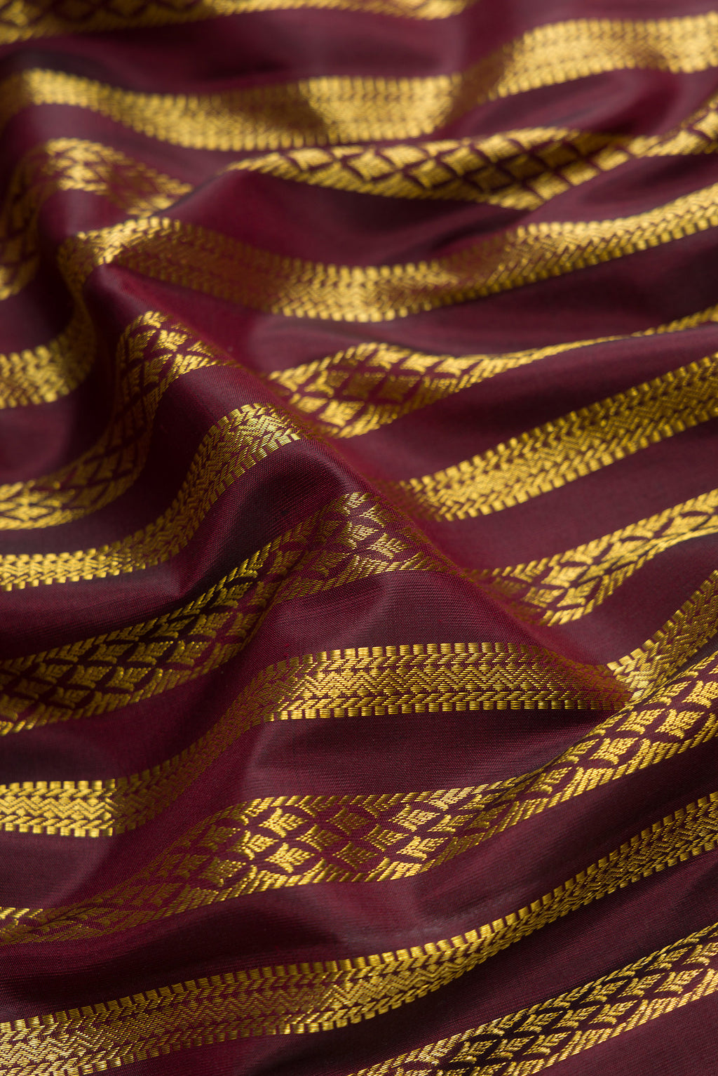 Close up of Coffee Brown Dual Tone Kanjivaram Silk Saree with Zari Brocade on the body and Zari Border.  displaying folds