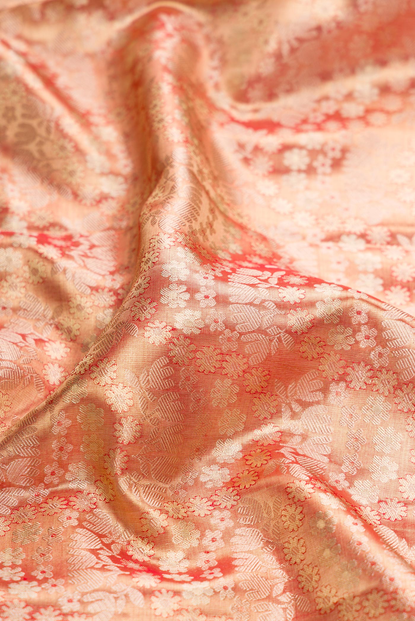Close up of Golden Peach Dual Tone Kanjivaram Tissue Silk Saree with Zari Brocade on the body and Zari Border.  displaying folds