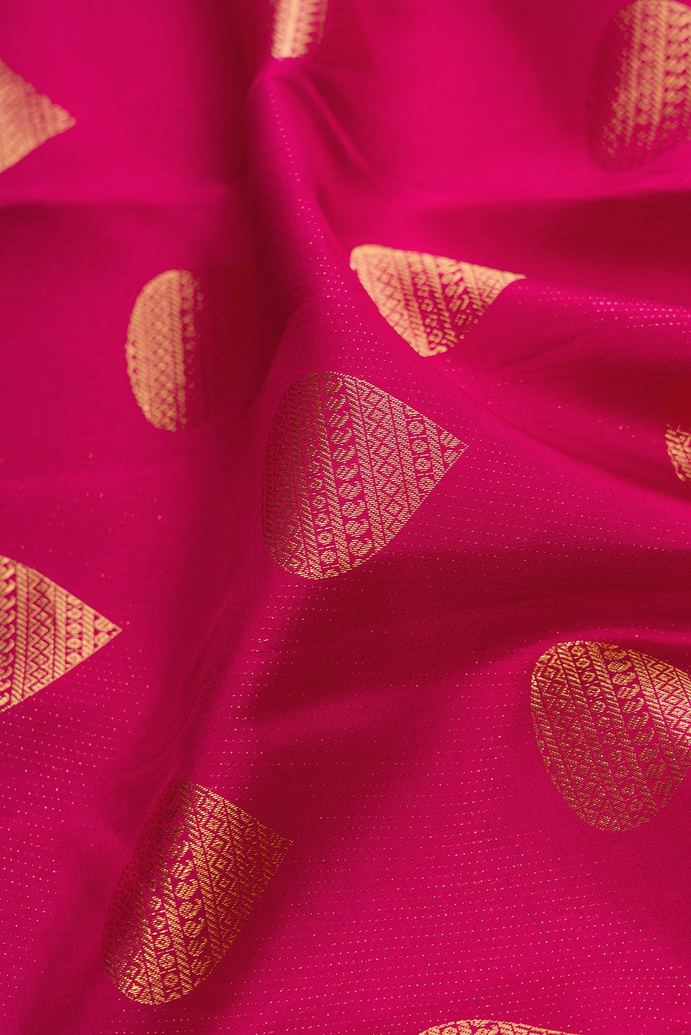 Close up of Magenta Dual Tone Kanchipuram Silk Saree with Zari Butta on the body and Fancy Border.  displaying folds