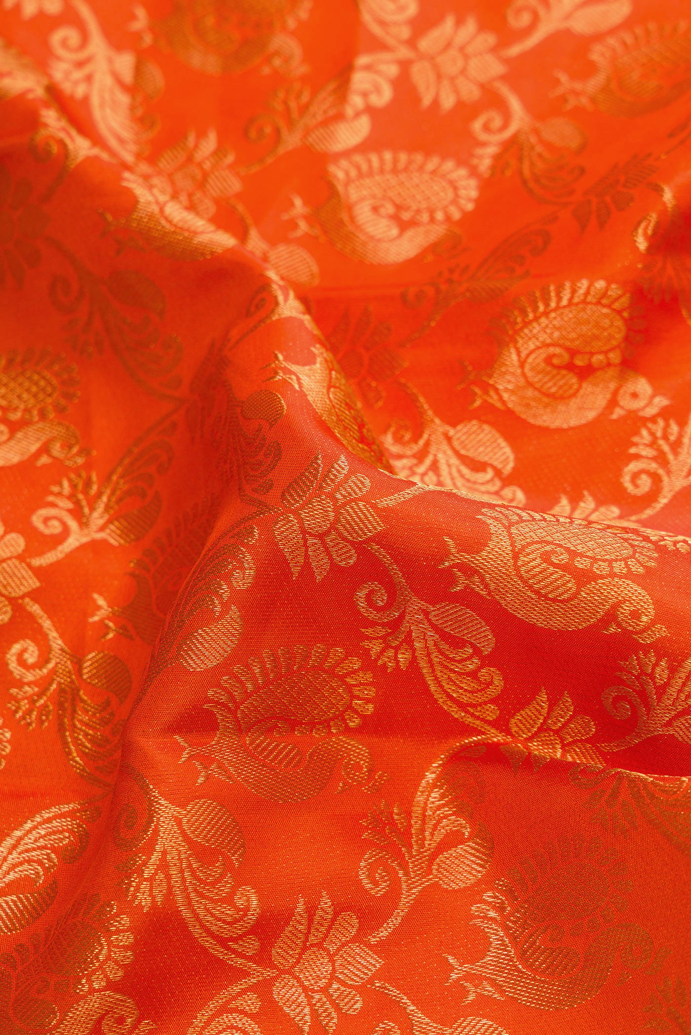 Close up of Orange Dual Tone Kanchipuram Silk Saree with Zari Brocade on the body and Zari Border.  displaying folds