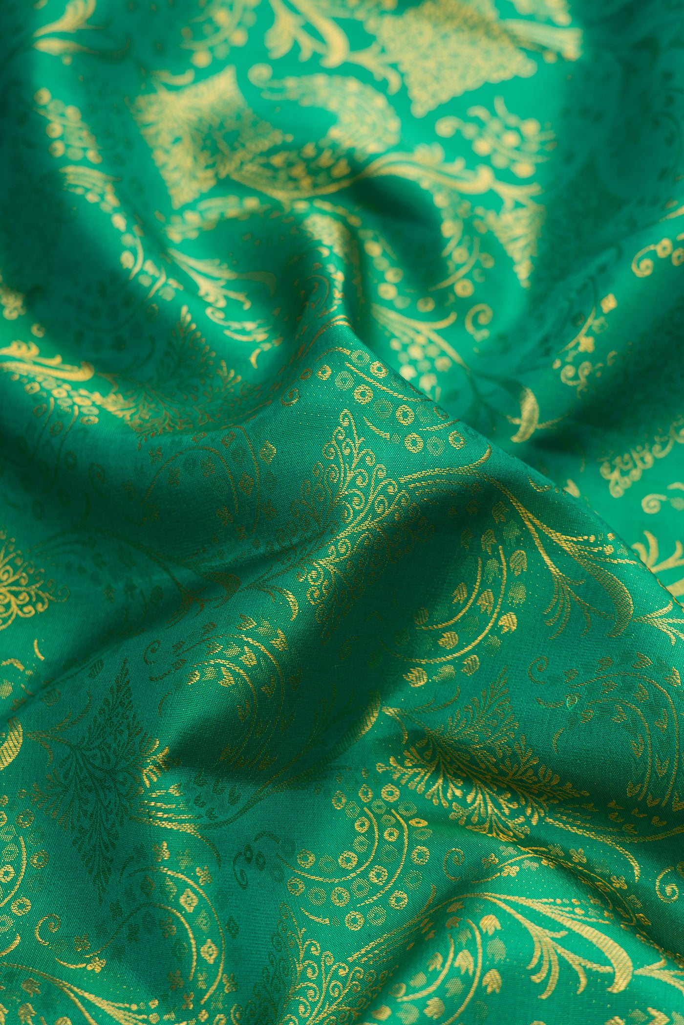 Close up of Green Dual Tone Kanchipuram Silk Saree with Zari Brocade on the body and Zari Border.  displaying folds