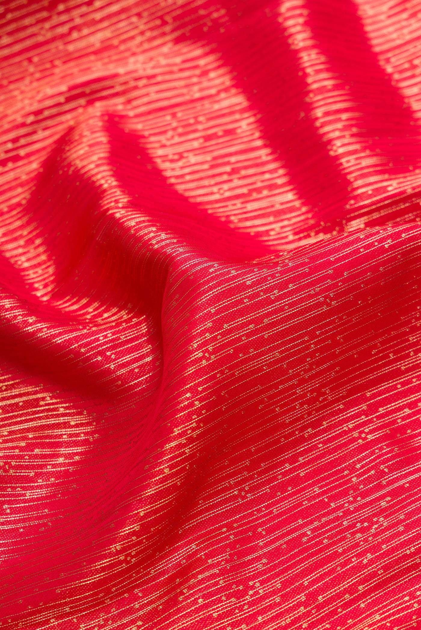 Close up of Red Dual Tone Kanjivaram Silk Saree with Zari Brocade on the body and Fancy Border.  displaying folds