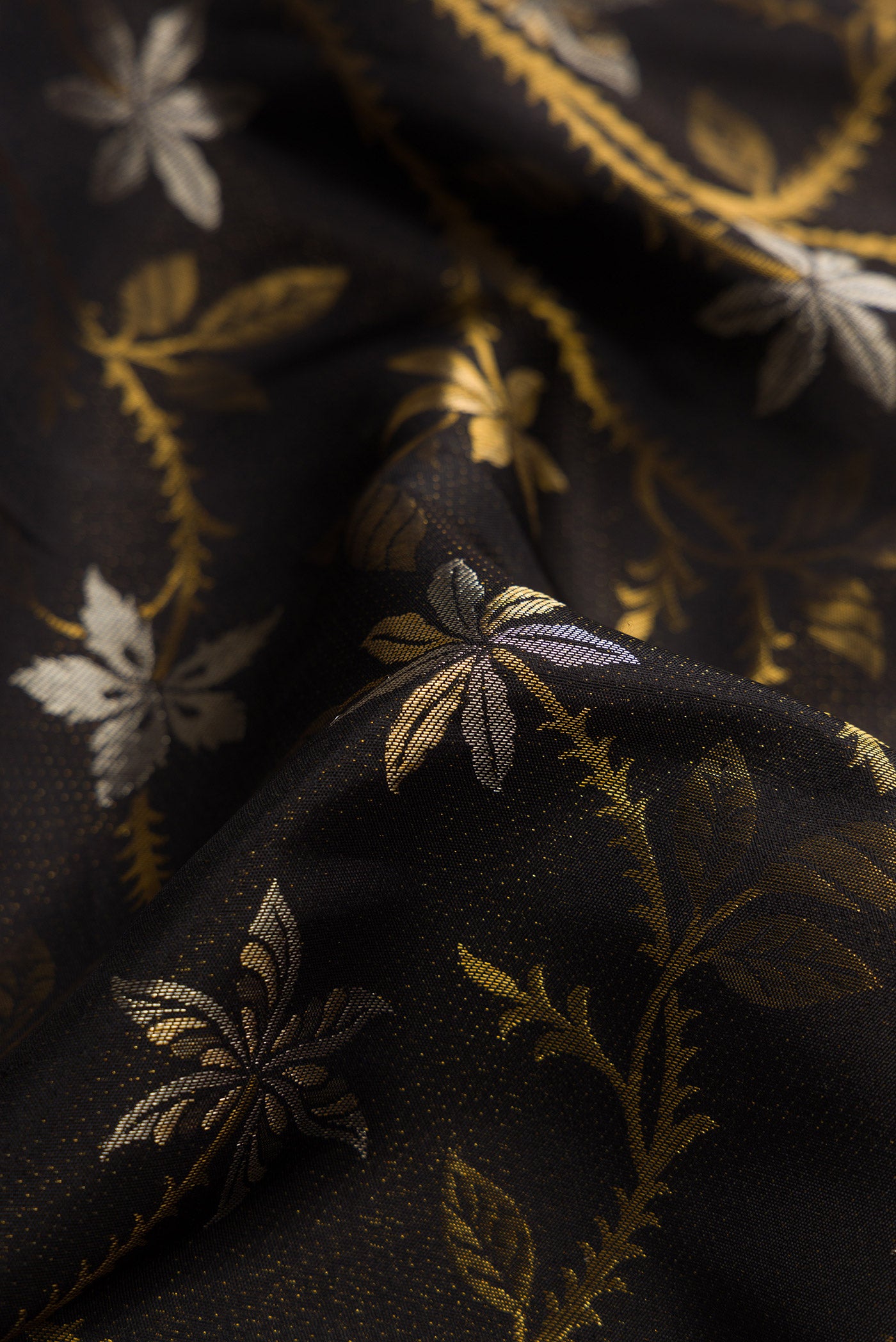 Close up of Black Dual Tone Kanjivaram Silk Saree with Zari Brocade on the body and Fancy Border.  displaying folds