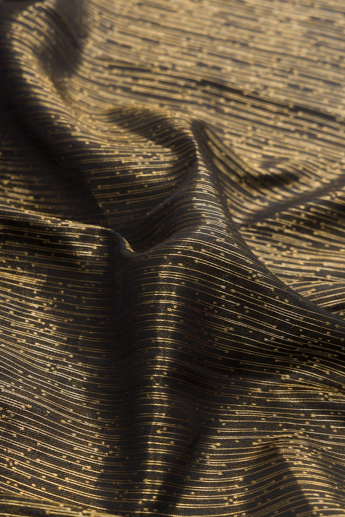 Close up of Black Dual Tone Kanjivaram Silk Saree with Zari Brocade on the body and Fancy Border.  displaying folds