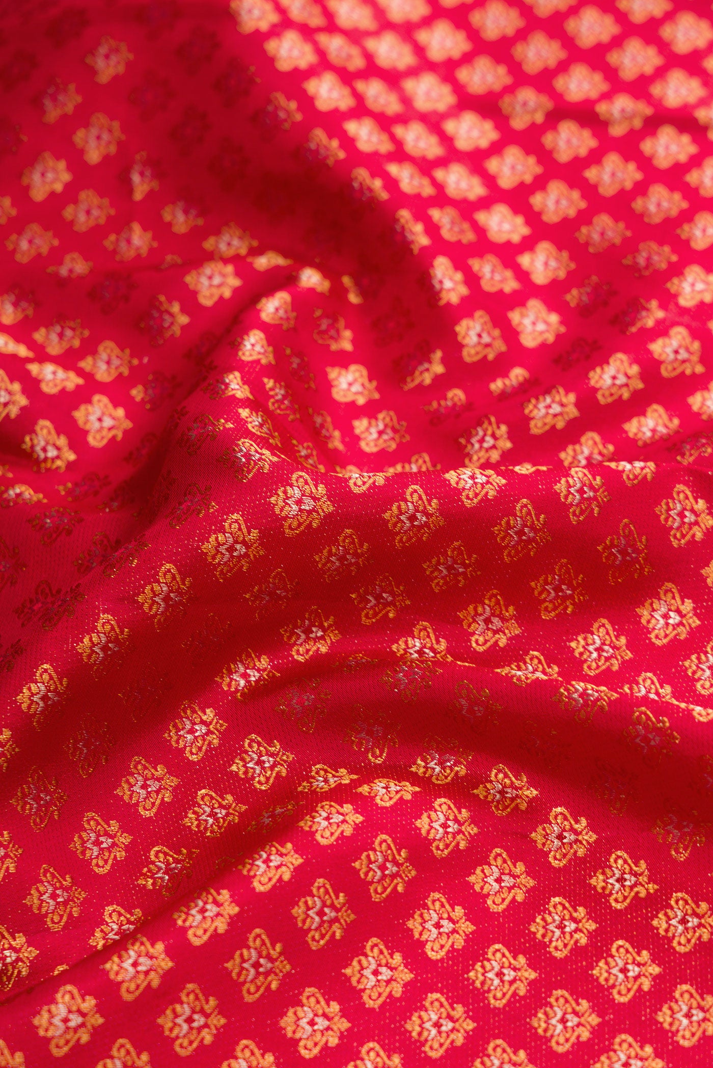 Close up of Red Dual Tone Kanjivaram Silk Saree with Zari Brocade on the body and Fancy Border.  displaying folds