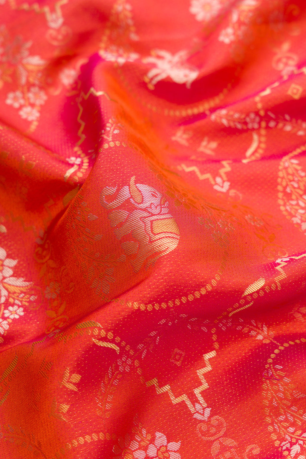 Close up of Brick Orange Dual Tone Kanjivaram Silk Saree with Zari Brocade on the body and Zari Border.  displaying folds