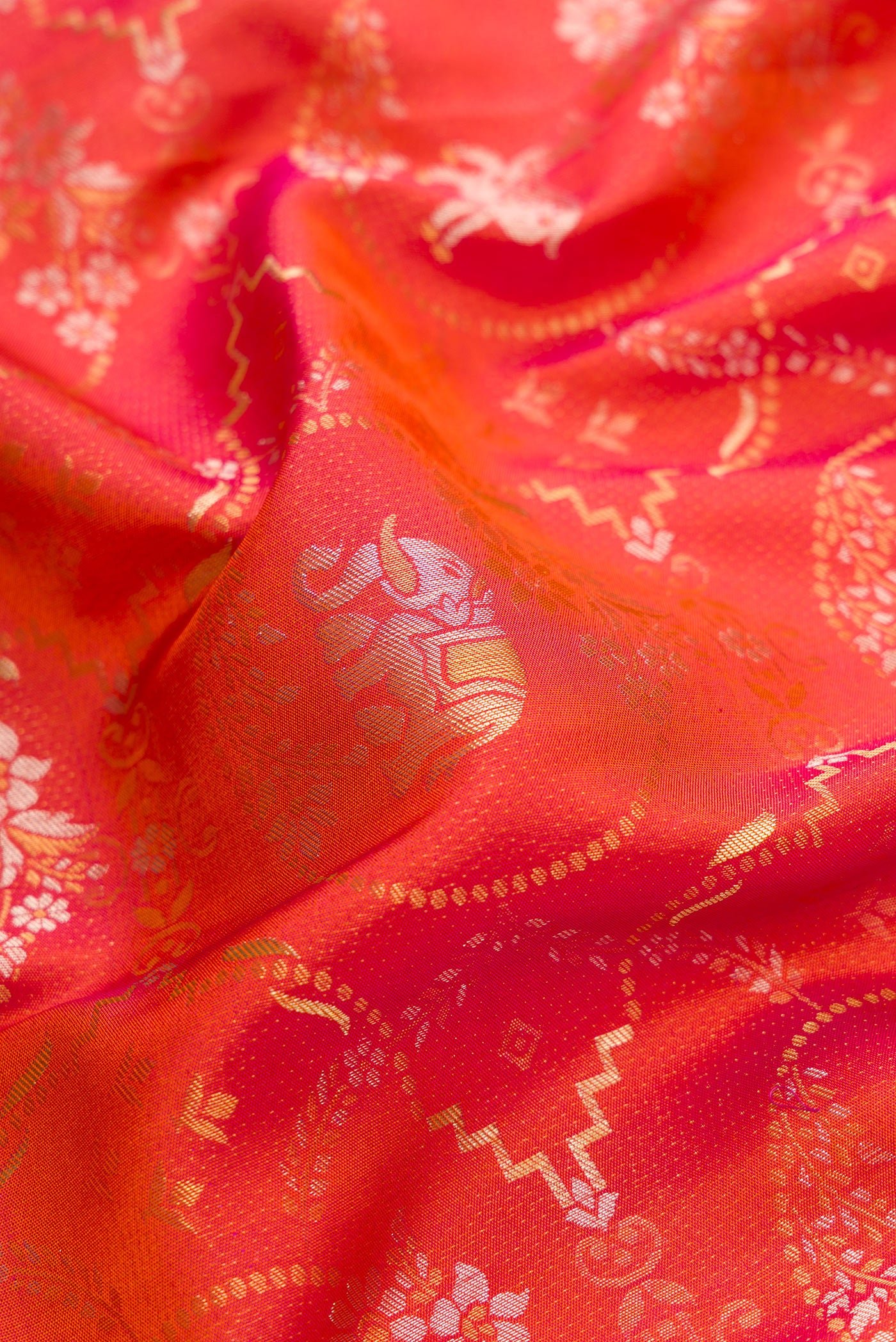Close up of Brick Orange Dual Tone Kanjivaram Silk Saree with Zari Brocade on the body and Zari Border.  displaying folds