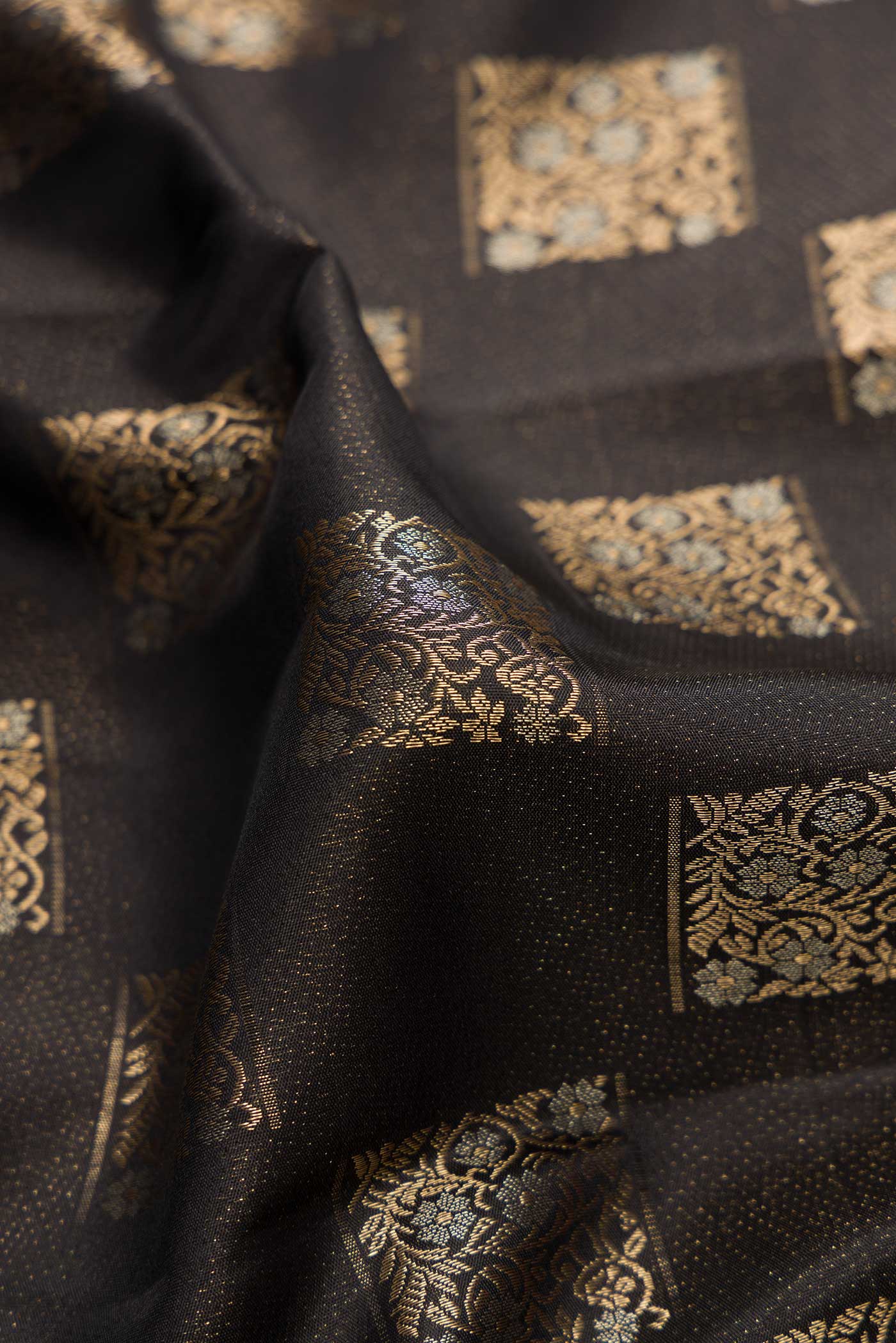Close up of Black Dual Tone Kanjivaram Silk Saree with Zari Butta on the body and Fancy Border.  displaying folds