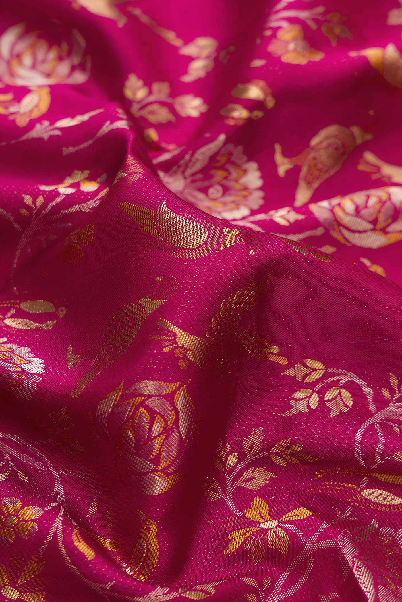 Close up of Magenta Dual Tone Kanjivaram Silk Saree with Zari Brocade on the body and Zari Border.  displaying folds