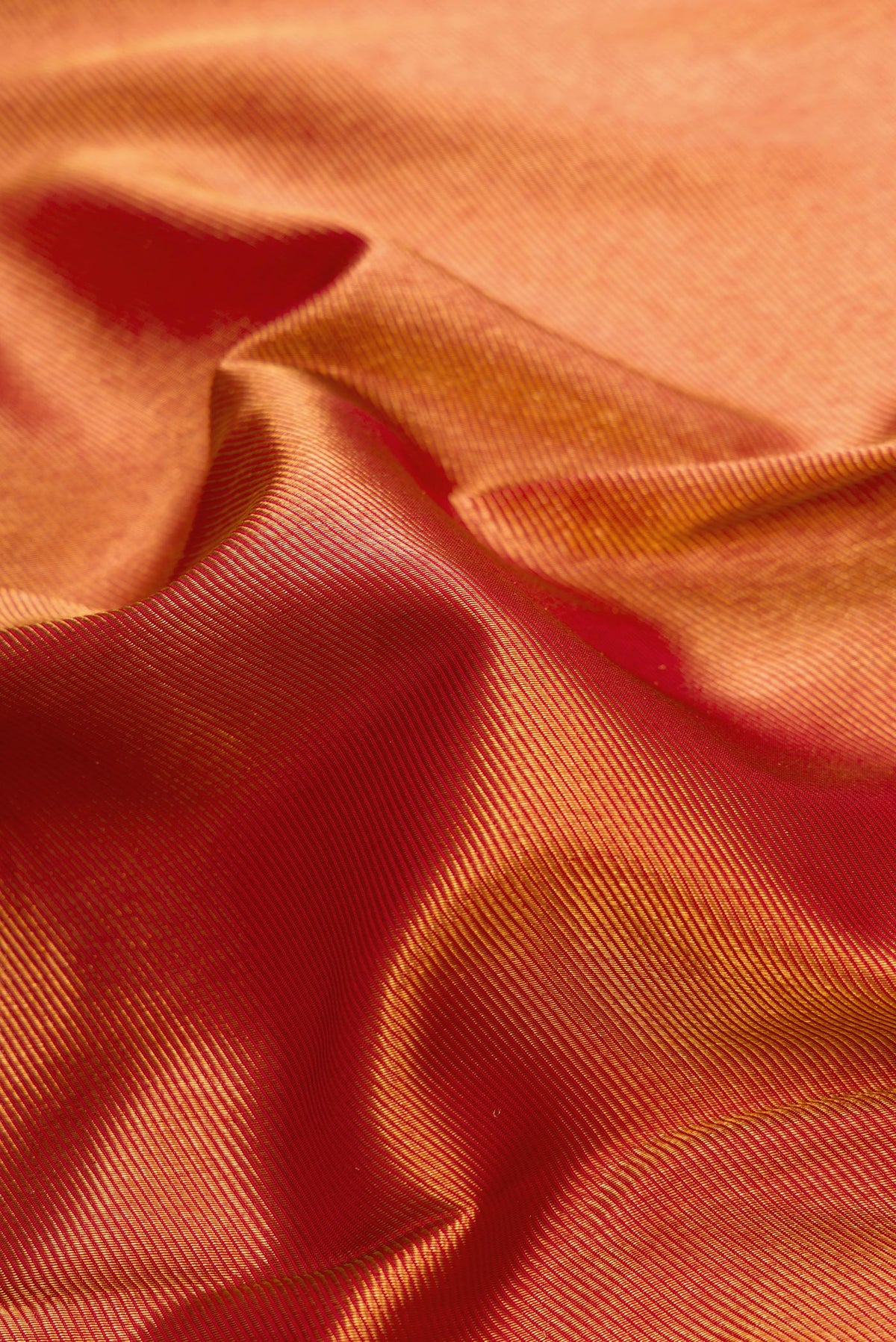 Close up of Red Dual Tone Kanjivaram Silk Saree with Zari Brocade on the body and Temple Border.  displaying folds