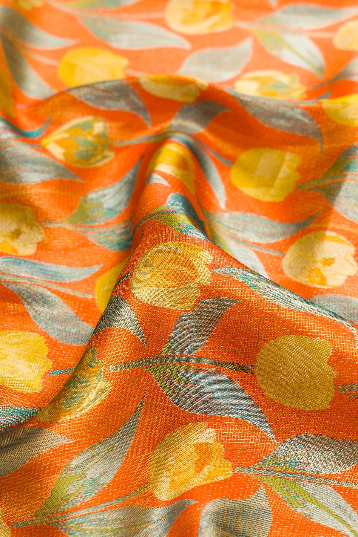 Close up of Orange Dual Tone Kanjivaram Tissue Silk Saree with Zari Brocade on the body and Zari Border.  displaying folds