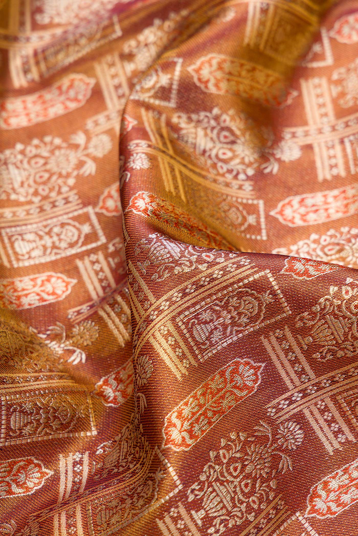 Close up of Brown Dual Tone Kanjivaram Tissue Silk Saree with Zari Brocade on the body and Fancy Border.  displaying folds
