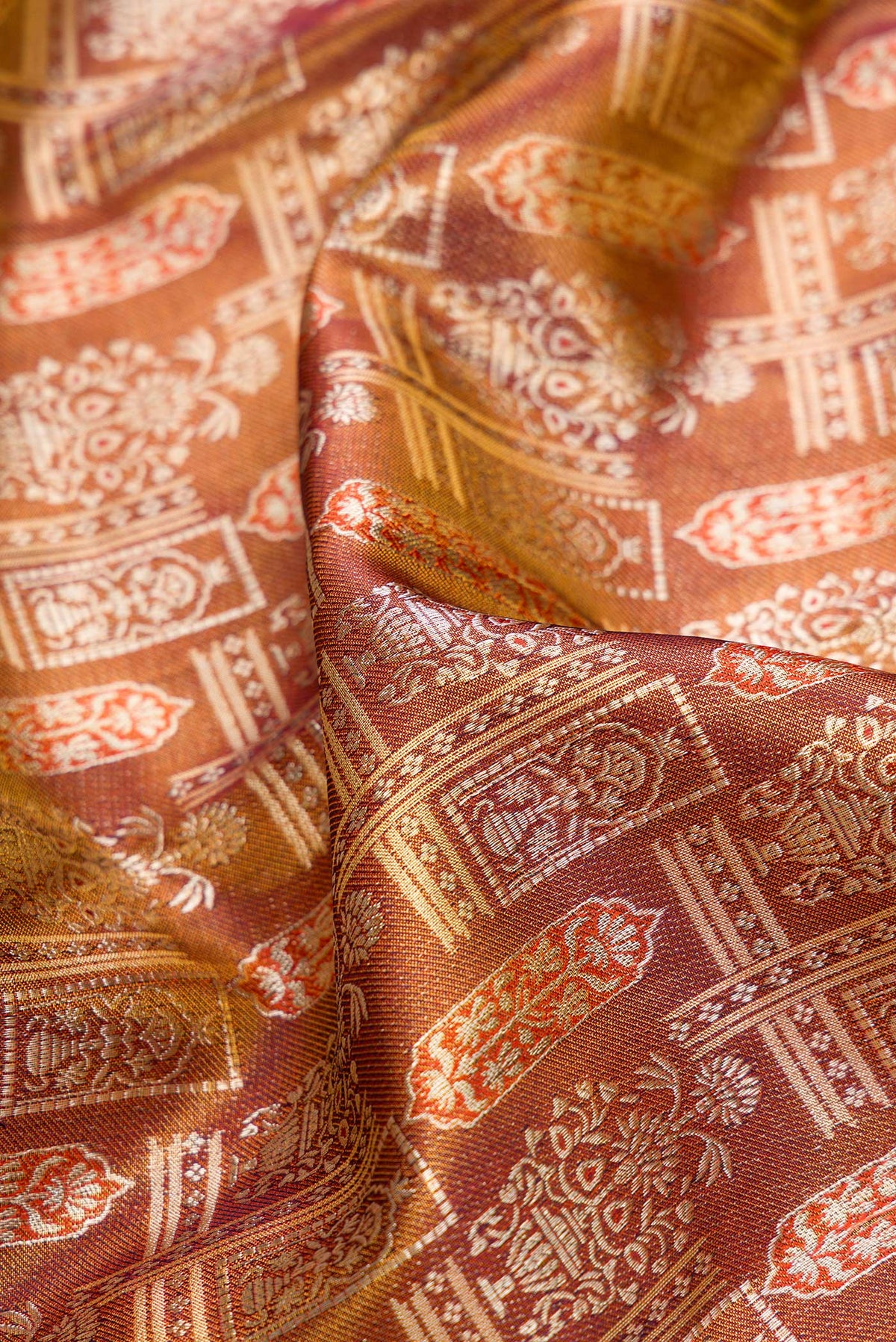 Close up of Brown Dual Tone Kanjivaram Tissue Silk Saree with Zari Brocade on the body and Fancy Border.  displaying folds