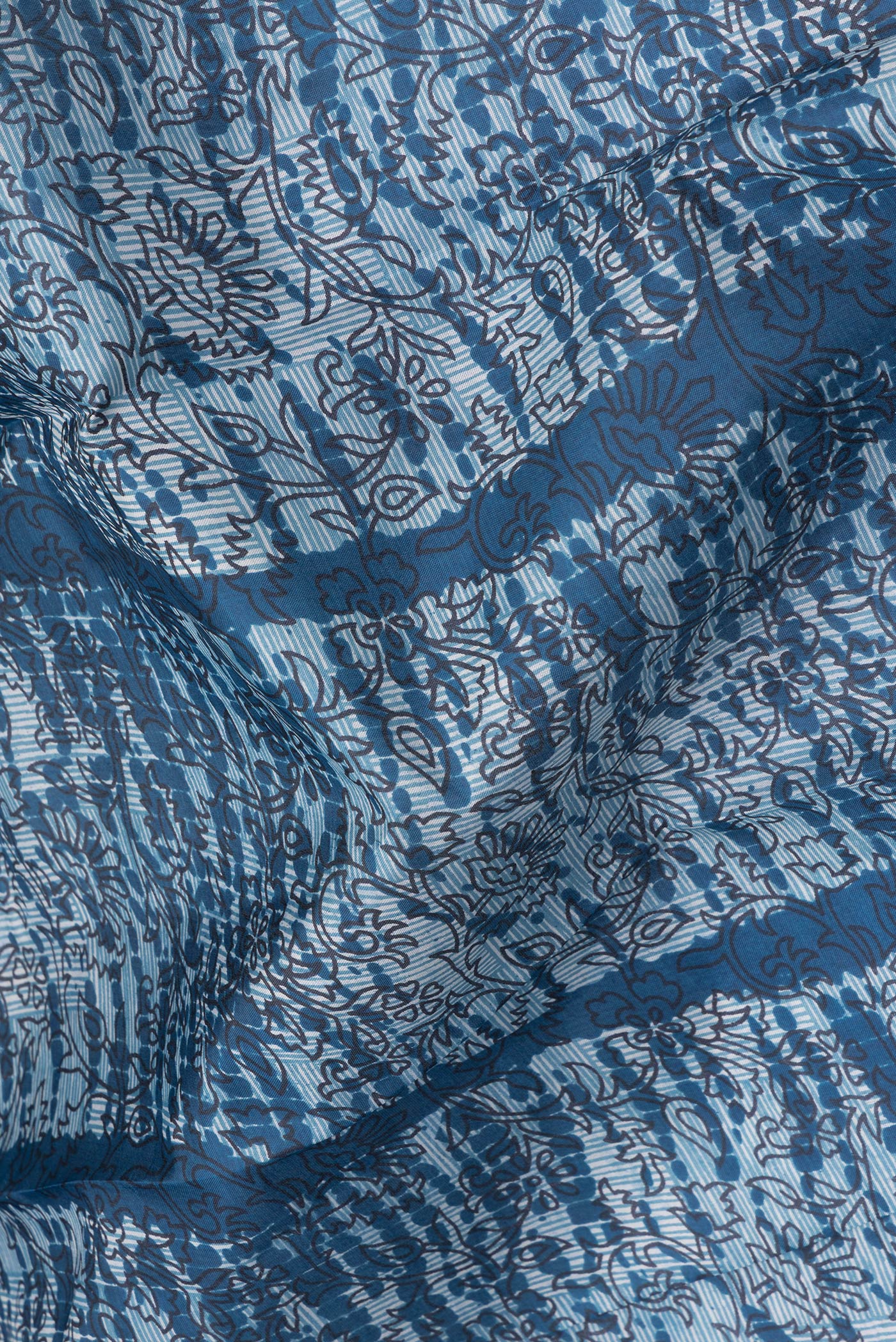 Close up of Peacock Blue Printed Silk Saree with Printed design on the body and Printed Border.  displaying folds
