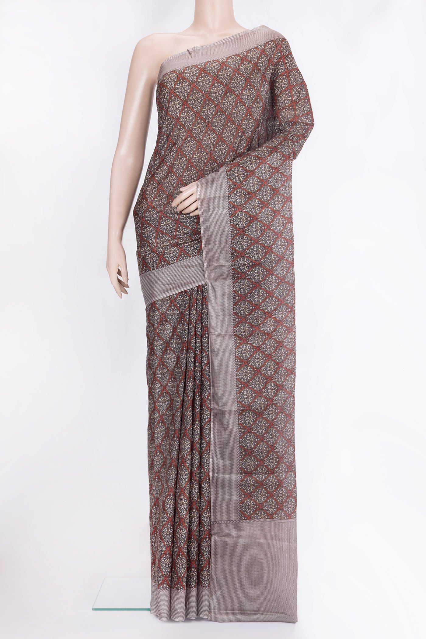 Brick Orange Printed Silk Saree with Printed design on the body and Printed Border.  displayed on a mannequin