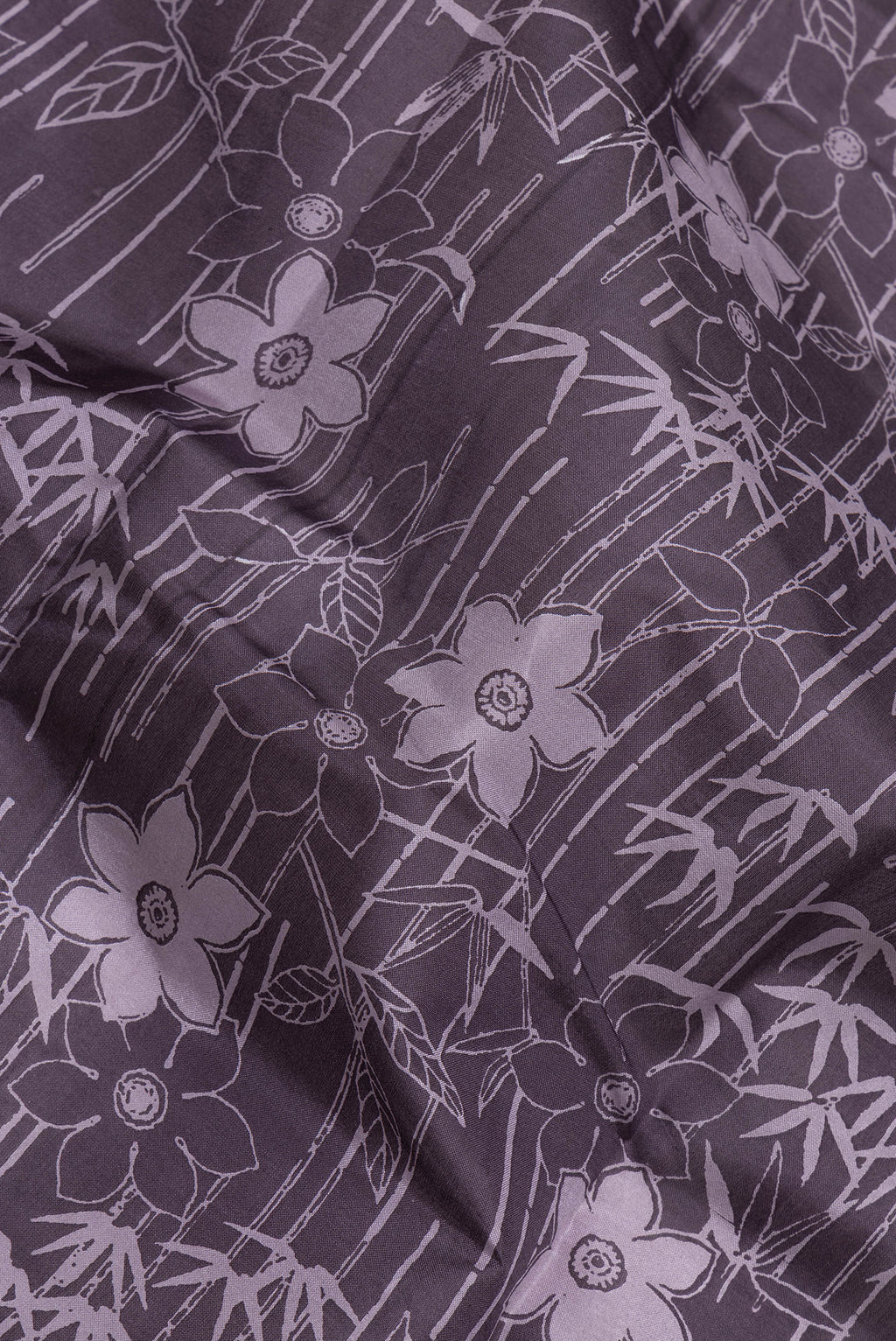 Close up of Purple Printed Silk Saree with Printed design on the body and Printed Border.  displaying folds