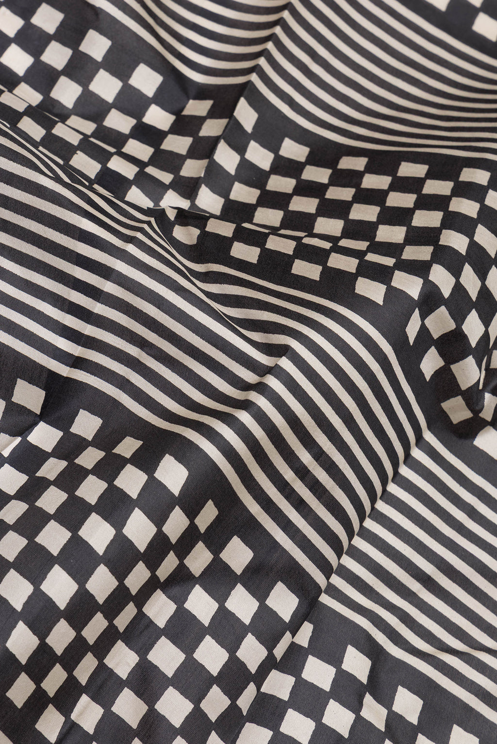 Close up of Black Printed Silk Saree with Printed design on the body and Printed Border.  displaying folds