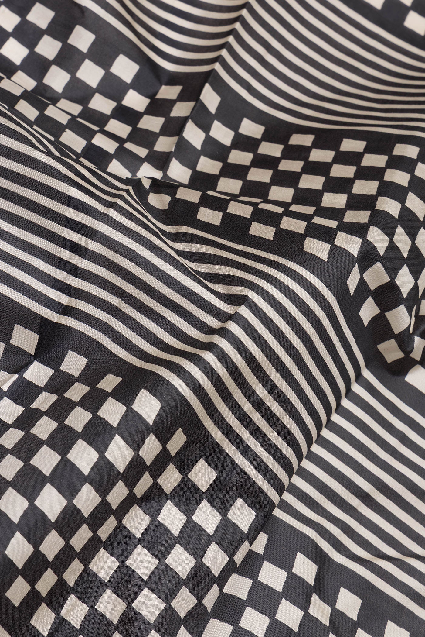 Close up of Black Printed Silk Saree with Printed design on the body and Printed Border.  displaying folds