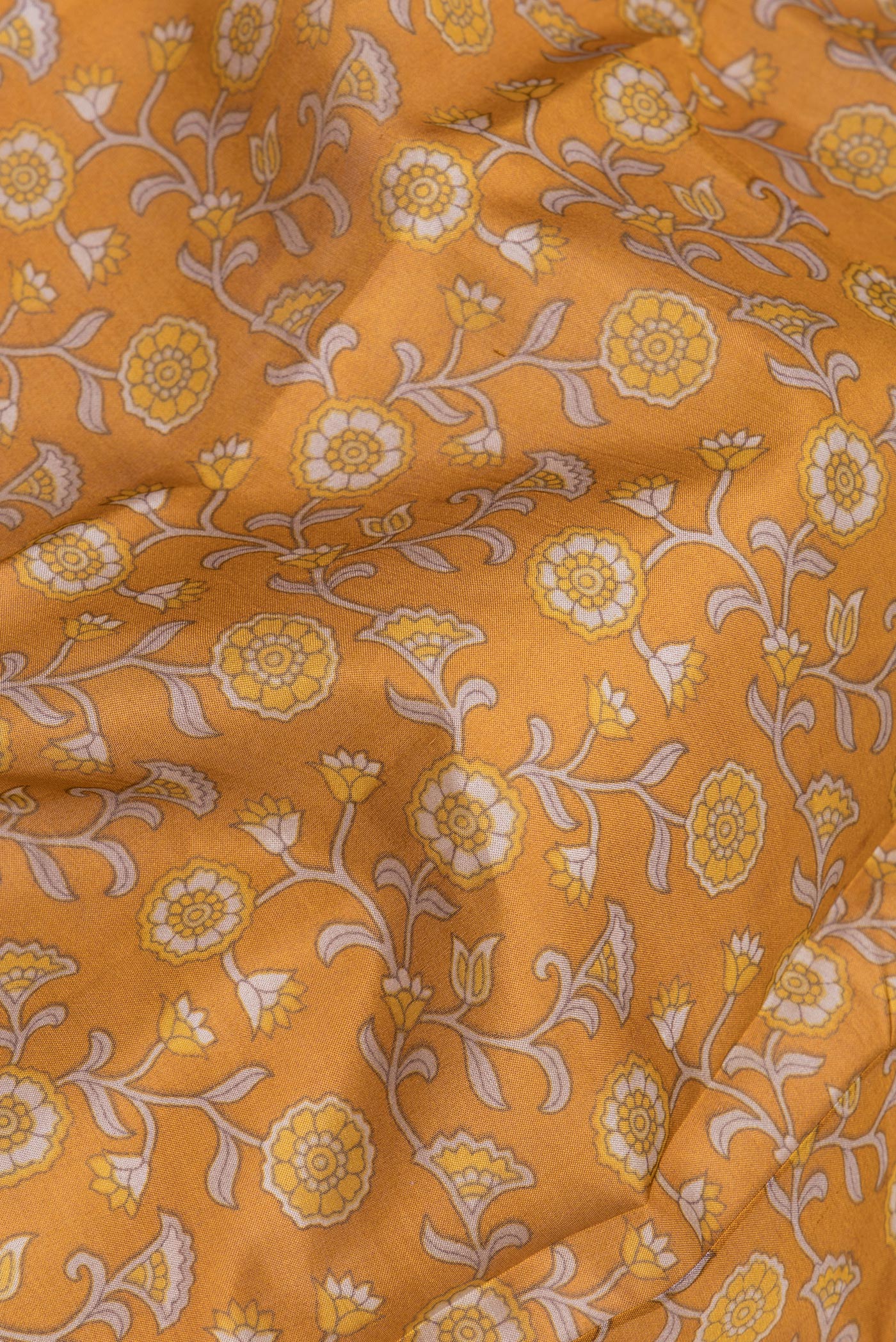 Close up of Mustard Printed Silk Saree with Printed design on the body and Printed Border.  displaying folds