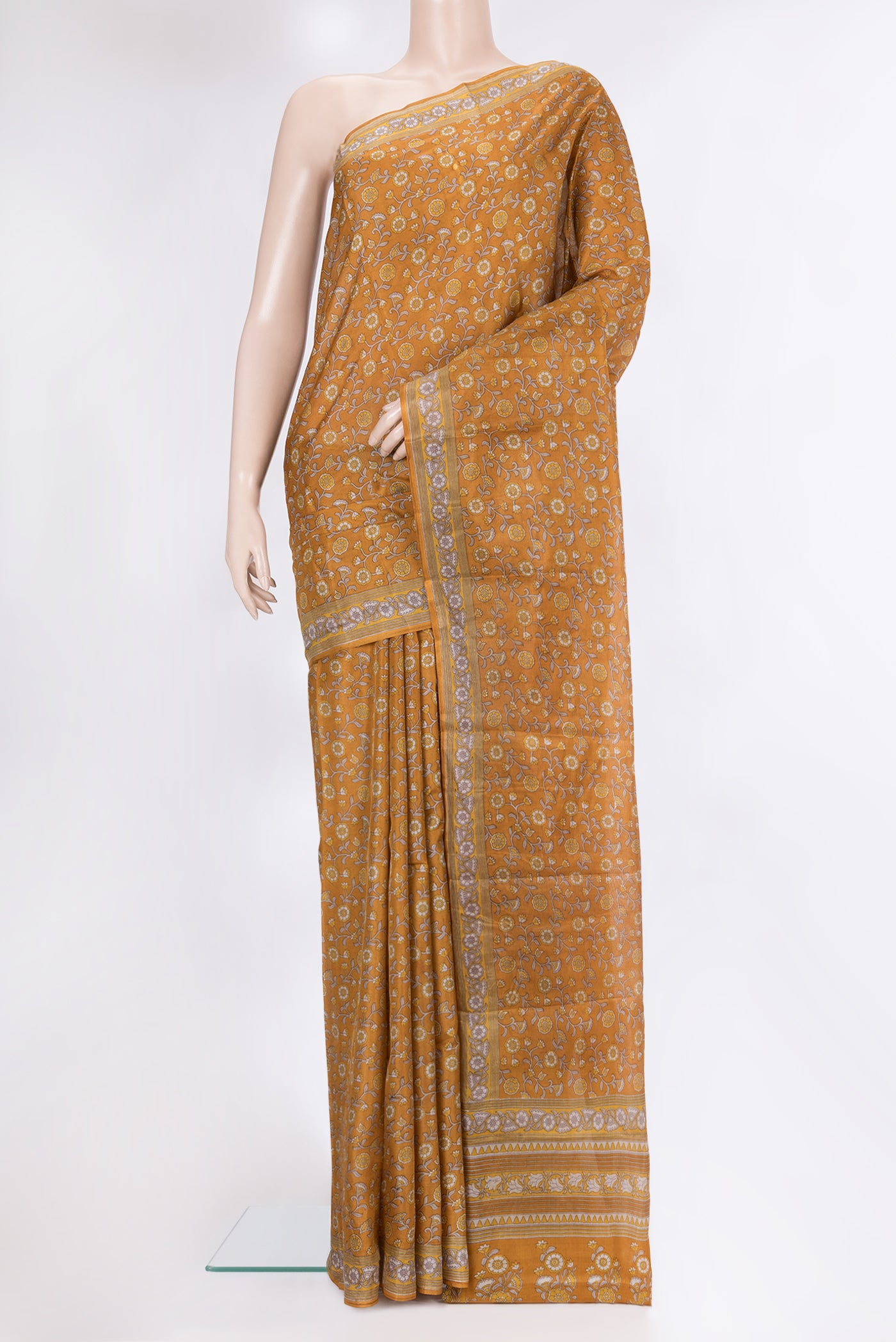 Mustard Printed Silk Saree with Printed design on the body and Printed Border.  displayed on a mannequin