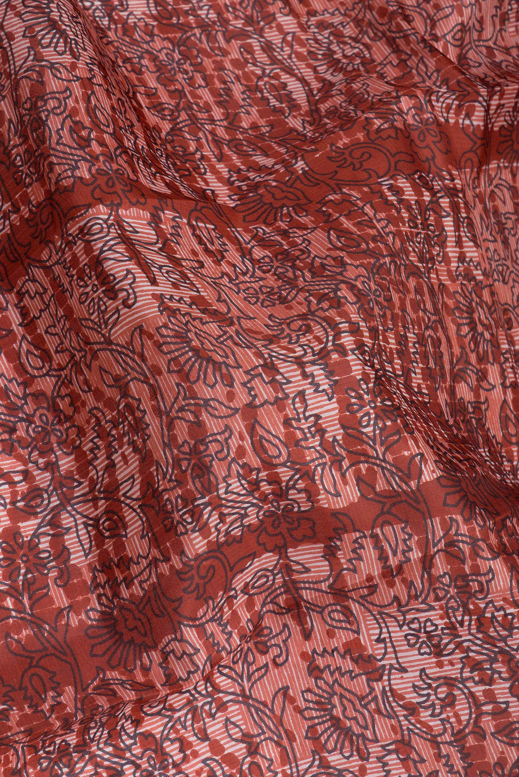 Close up of Rust Printed Silk Saree with Printed design on the body and Printed Border.  displaying folds