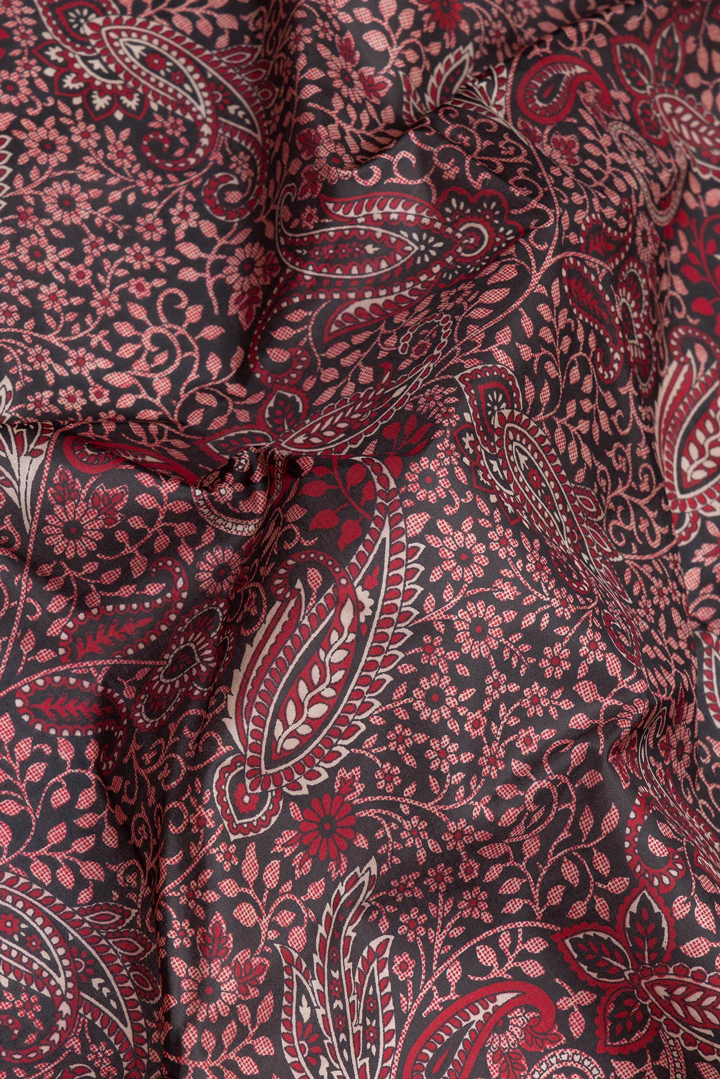 Close up of Black Printed Silk Saree with Printed design on the body and Thread Border.  displaying folds