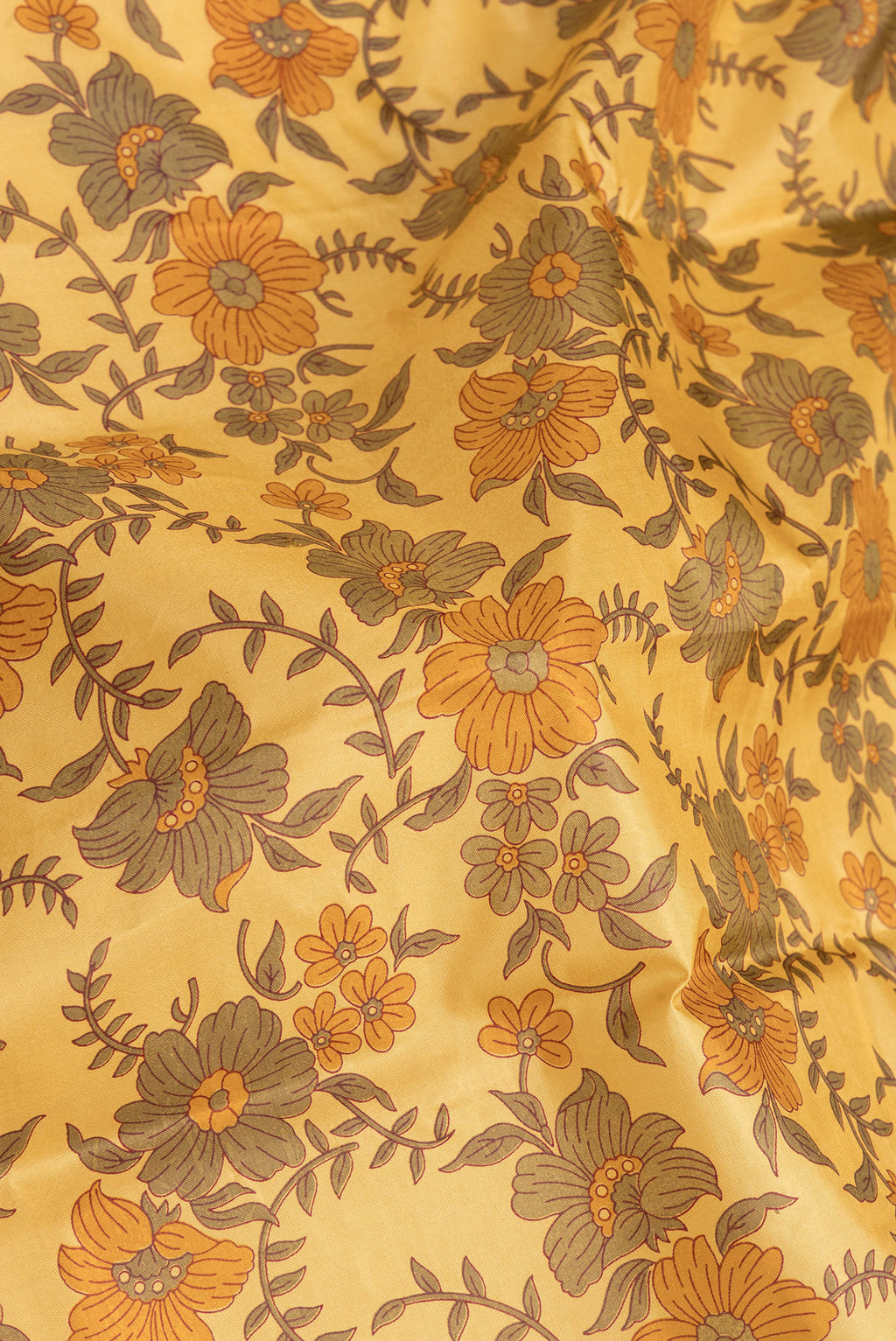 Close up of Yellow Dual Tone Tussar Silk Saree with Printed design on the body and Without Border.  displaying folds