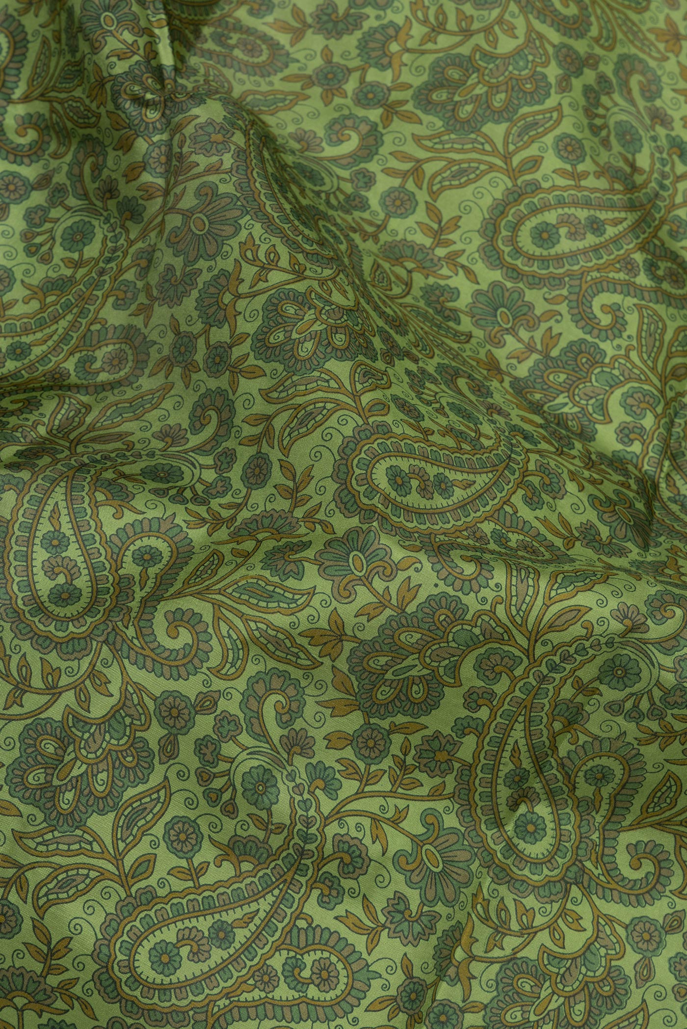 Close up of Green Printed Silk Saree with Printed design on the body and Without Border.  displaying folds
