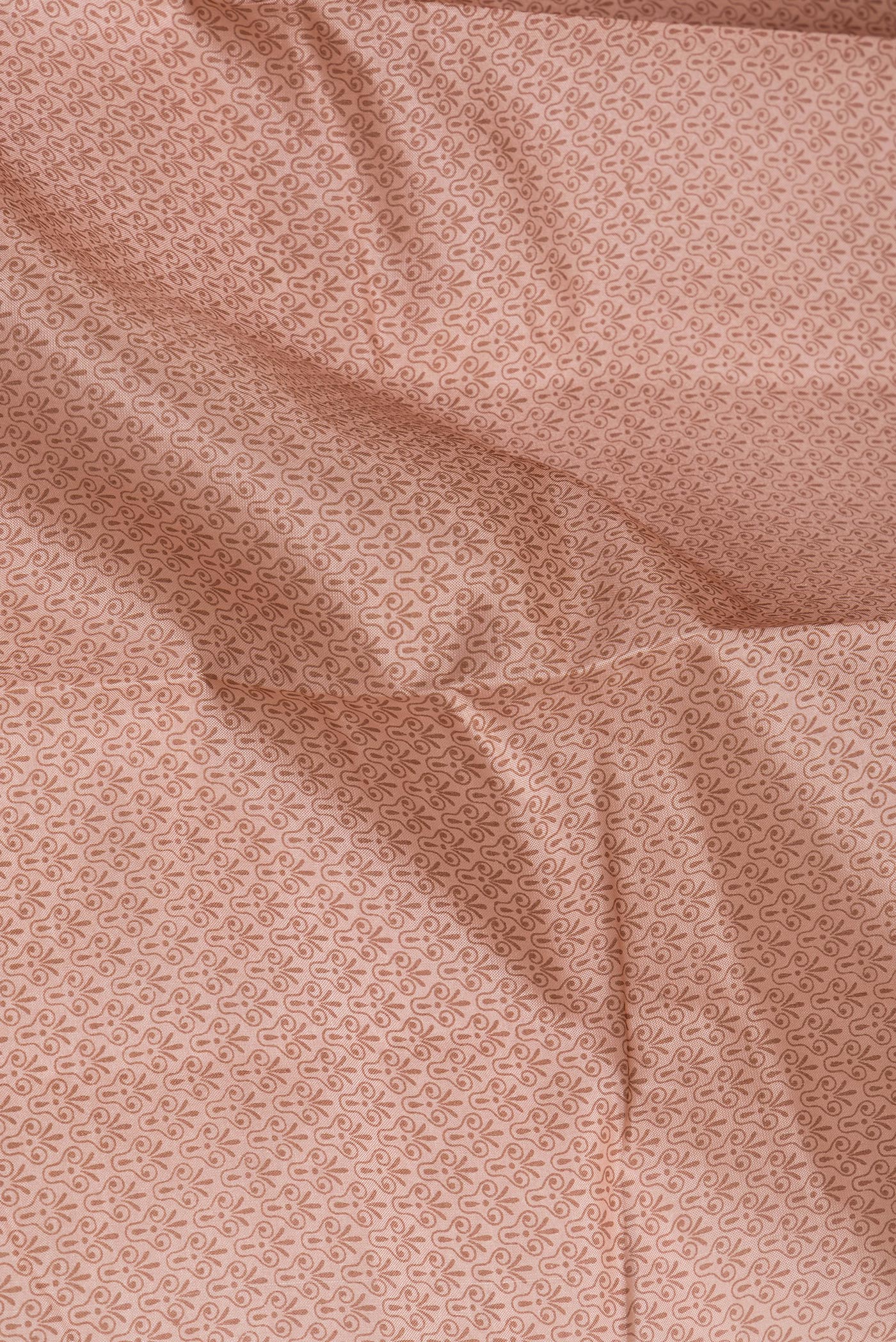 Close up of Golden Peach Printed Silk Saree with Printed design on the body and Printed Border.  displaying folds
