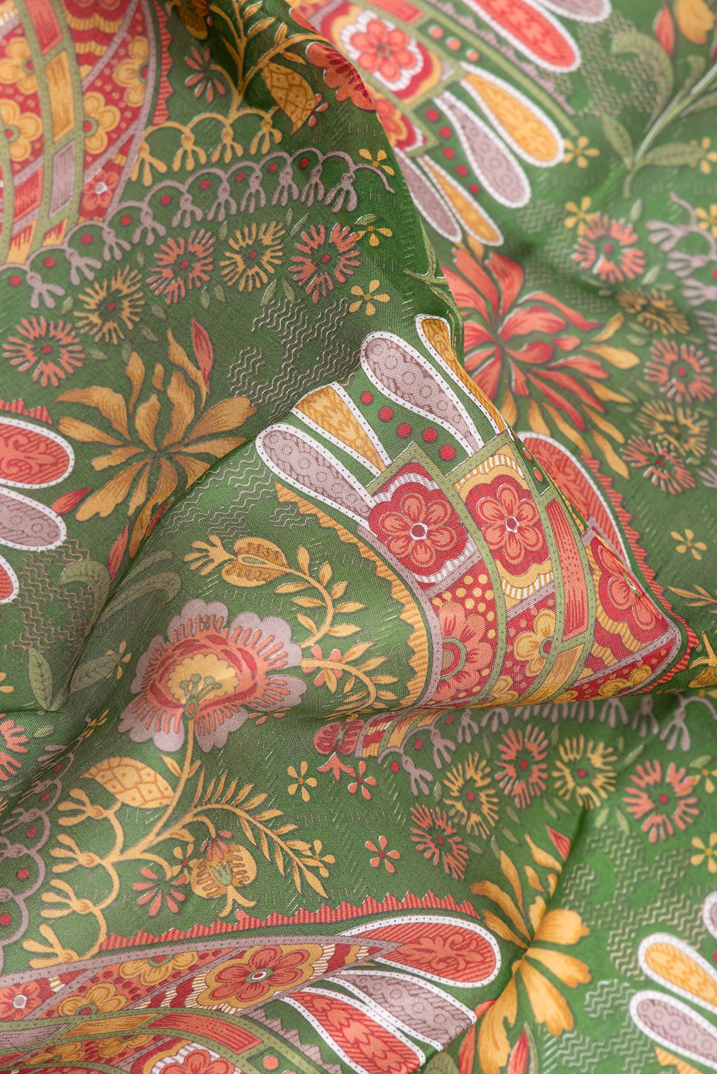 Close up of Green Printed Silk Saree with Printed design on the body and Printed Border.  displaying folds