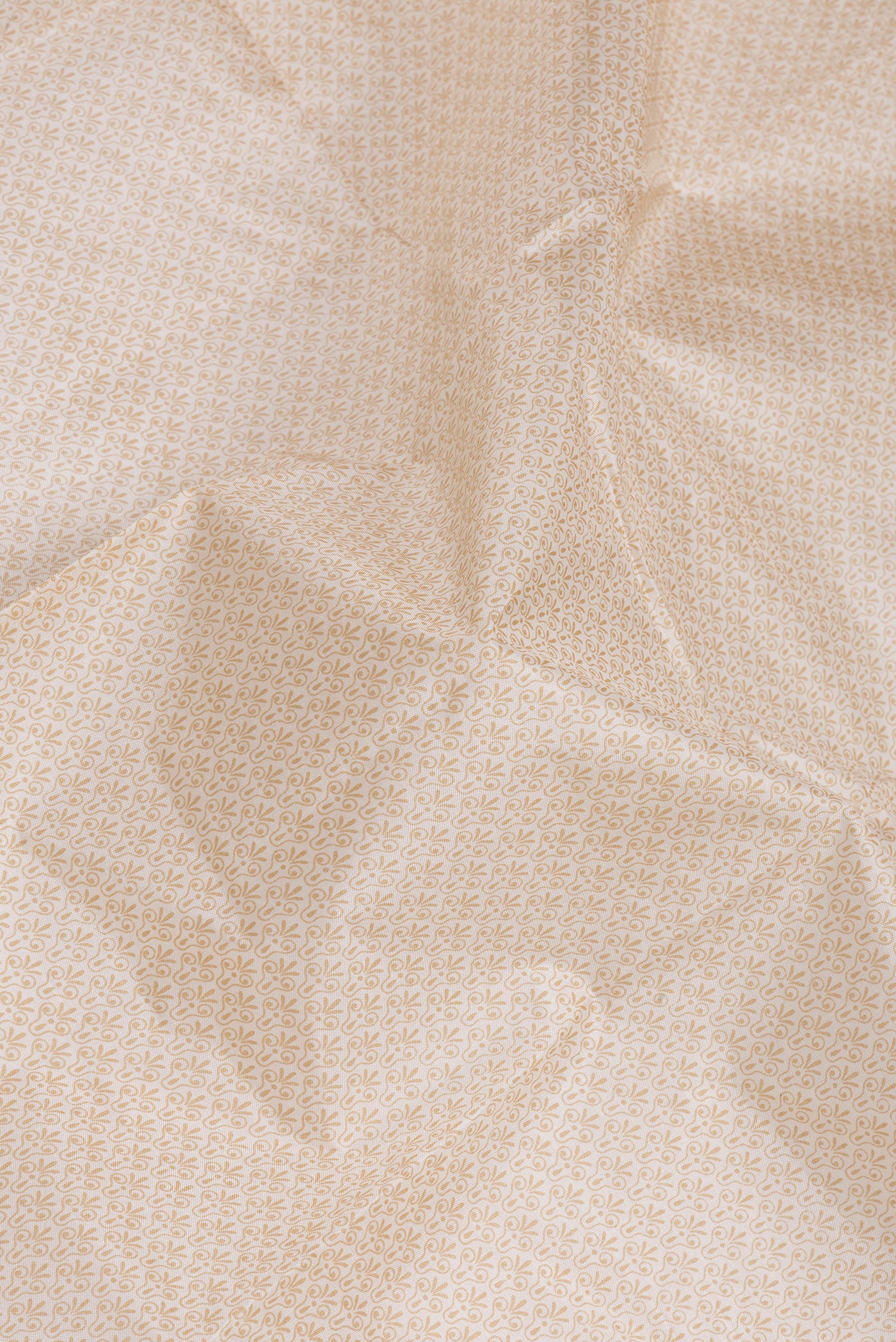 Close up of Beige Printed Silk Saree with Printed design on the body and Printed Border.  displaying folds
