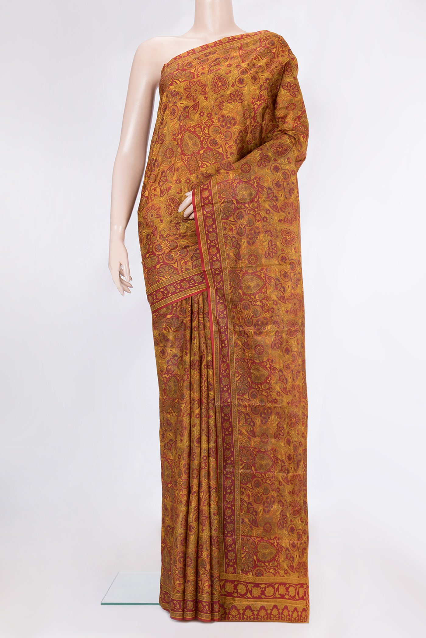 Mustard Printed Silk Saree with Printed design on the body and Printed Border.  displayed on a mannequin