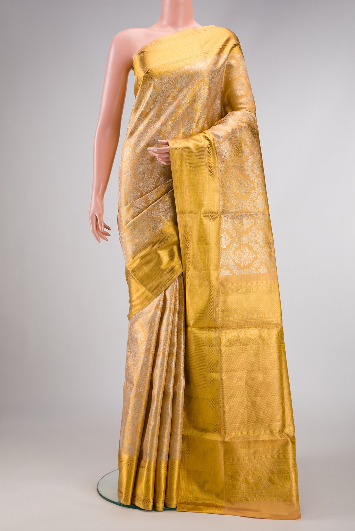Gold Dual Tone Kanjivaram Tissue Silk Saree with Zari Brocade on the body and Zari Border.  displayed on a mannequin