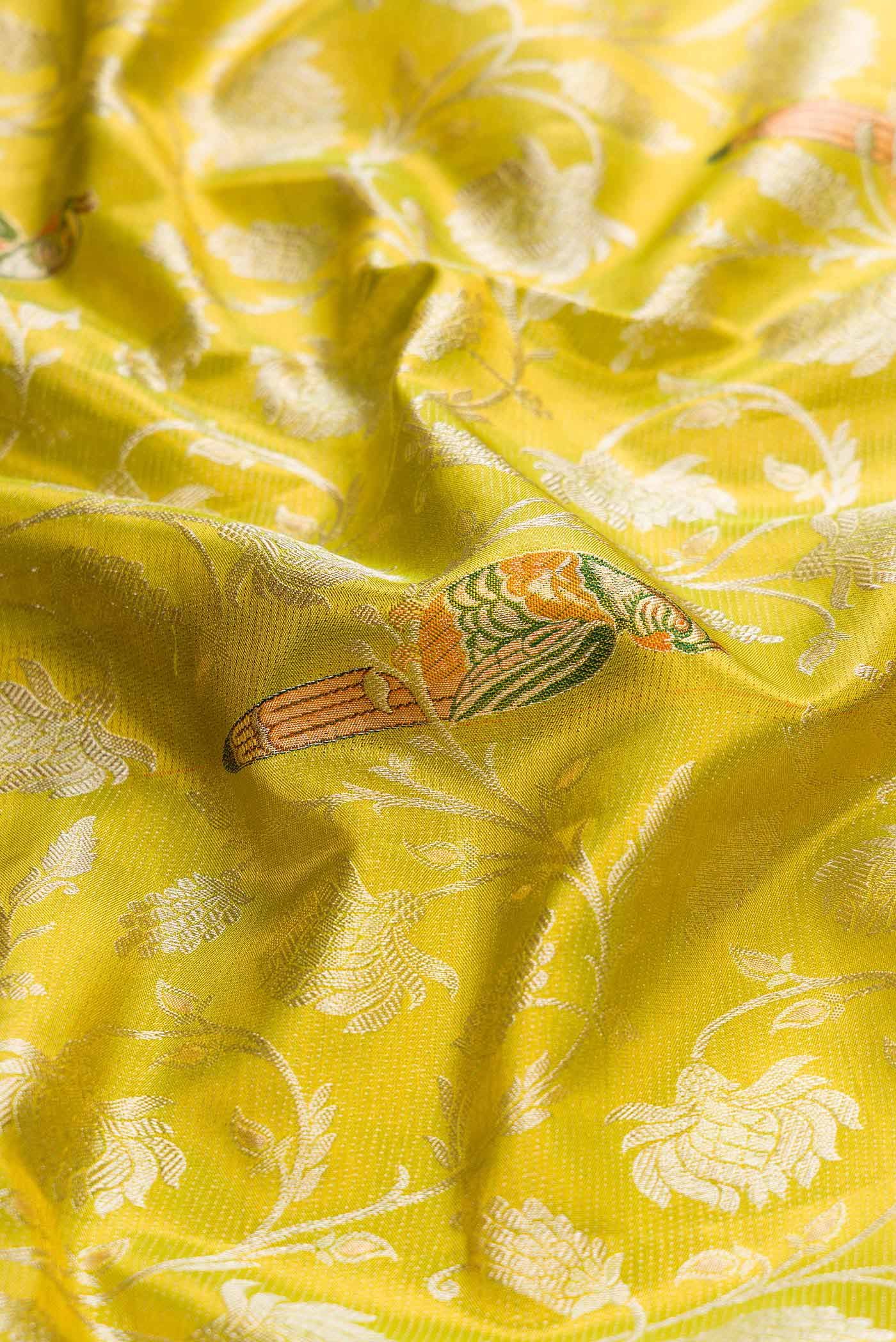 Close up of Parrot Green Dual Tone Kanchipuram Tissue Silk Saree with Zari Brocade on the body and Zari Border displaying folds