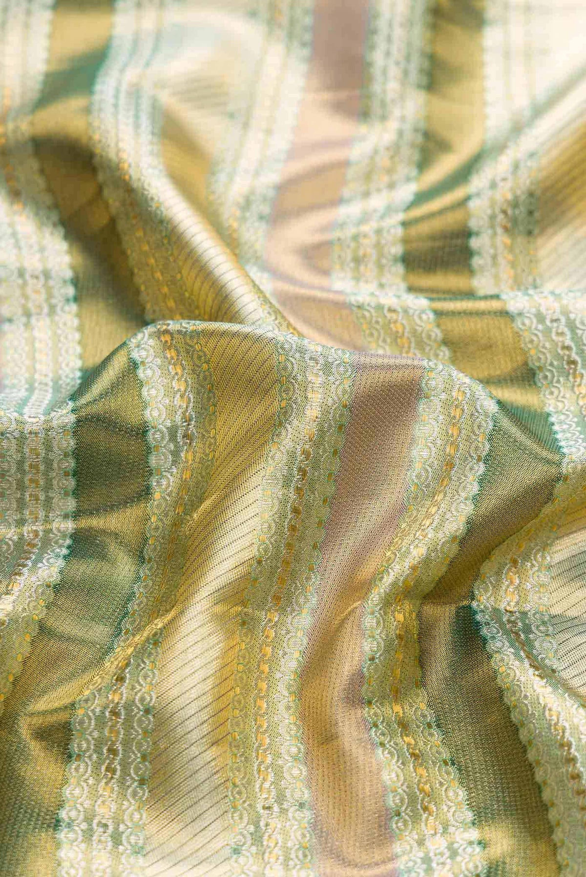 Close up of Green Dual Tone Kanchipuram Tissue Silk Saree with Zari Brocade on the body and Zari Border displaying folds